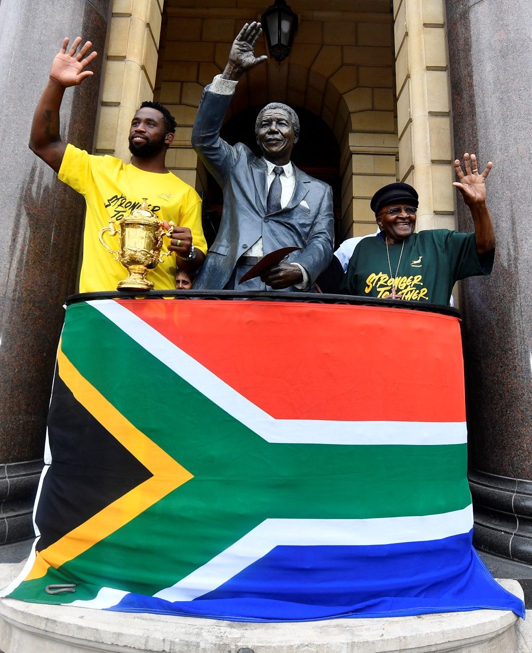 До статуята на Мандела в Кейптаун, капитанът на Южна Африка Сиа Колиси показва на стотици хиляди фенове купата на световен шампион в ръгби, спечелена в Япония.