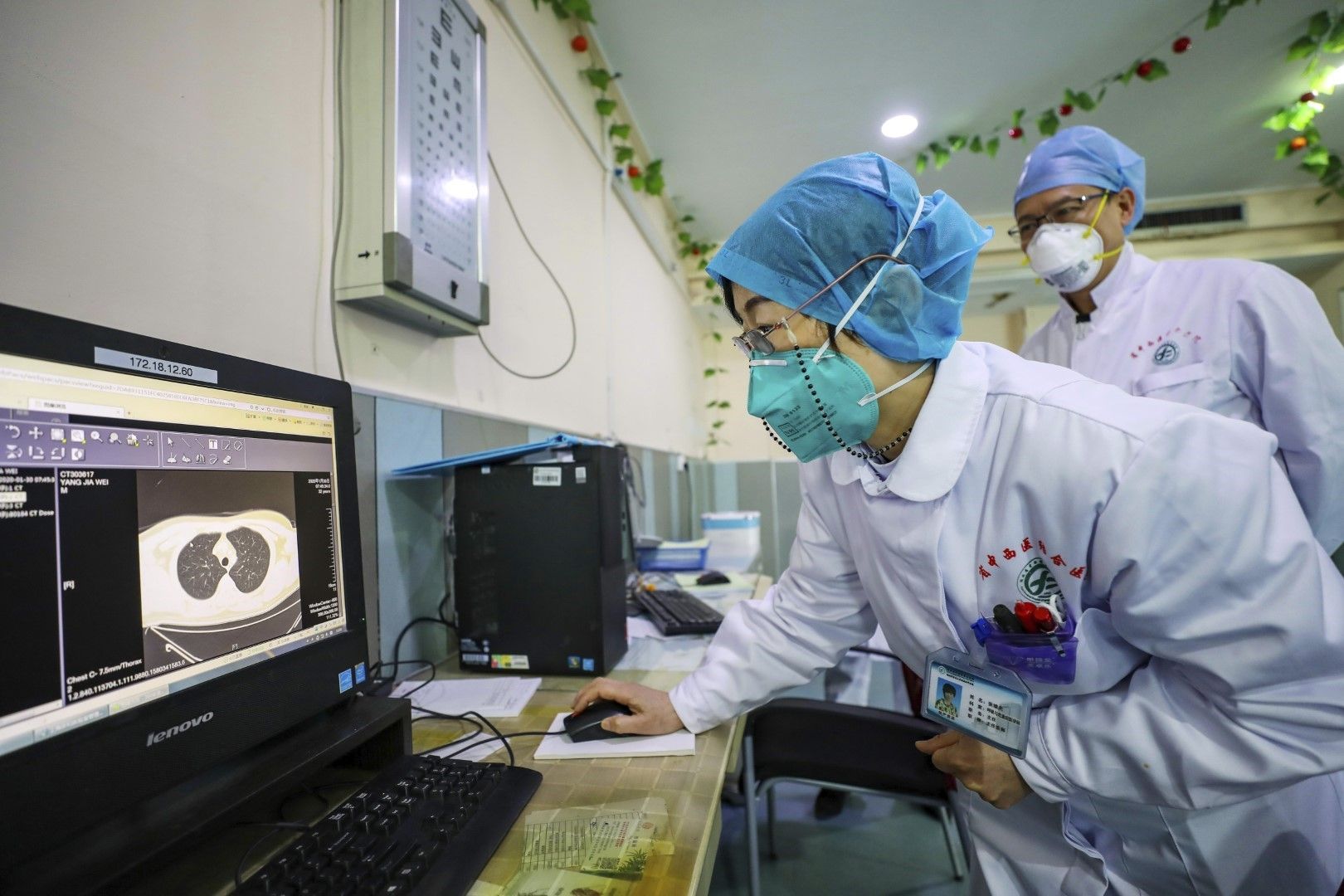Медици гледат клиничната картина на пациент в болницата в Ухан