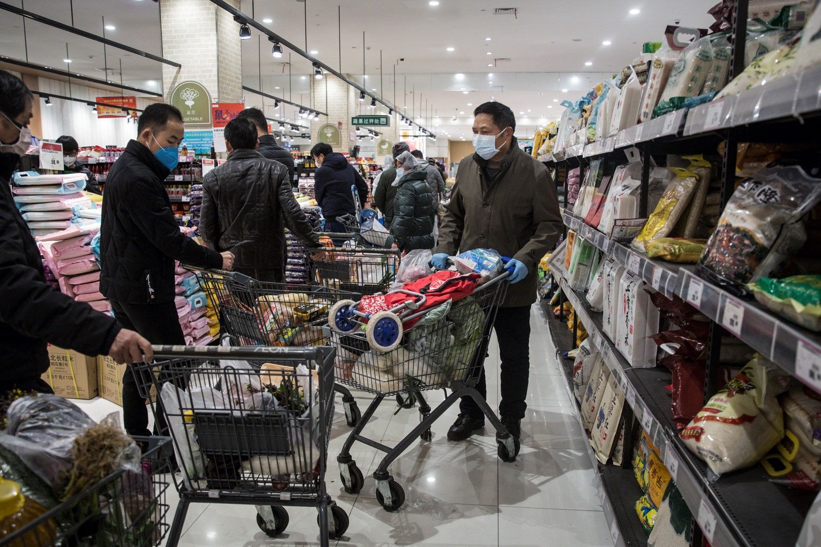 14 февруари. Животът в Ухан, провинция Хубей, продължава: мъже с маски пазаруват в супермаркет. Според изследването на китайските власти мъжете са по застрашени от заболяване, причинено от новия вирус