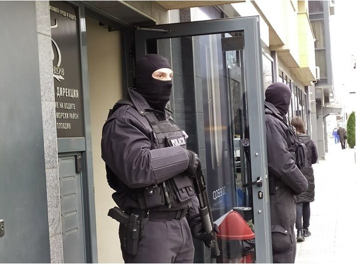 Полицейски бус и двама полицаи с маски и оръжия са на входа пред Басейнова дирекция