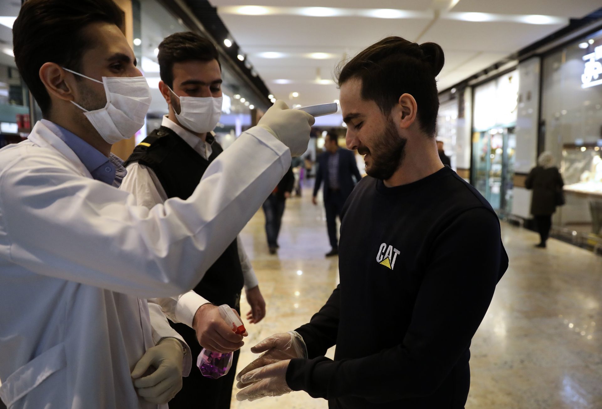 Мерят температурата и правят дезинфекция на ръцете при влиза в търговски център в Техеран 