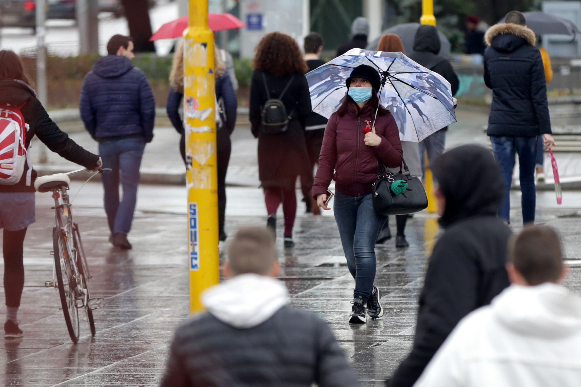 Жена с предпазна медицинска маска на лицето пресича кръстовището на Орлов мост