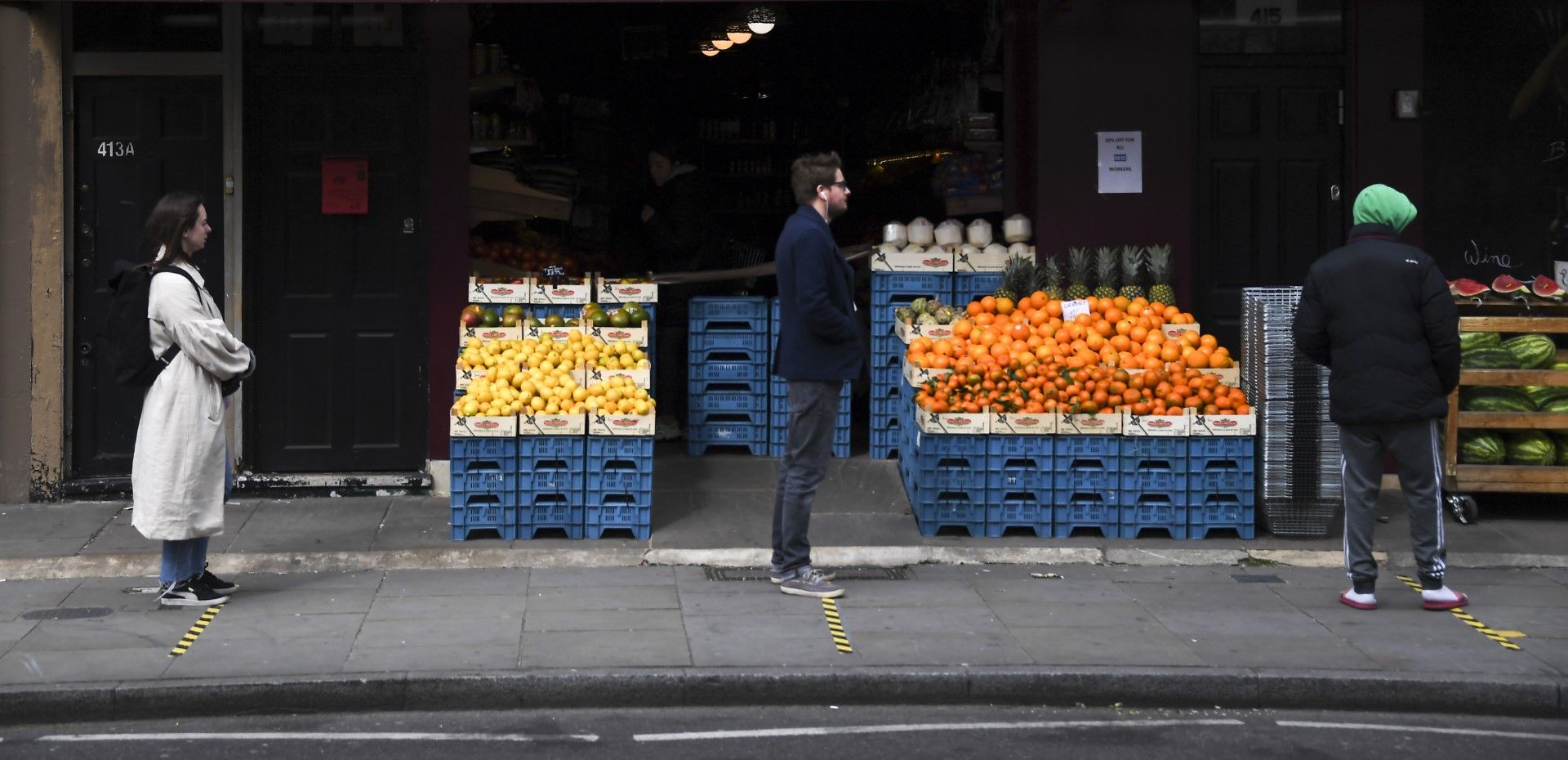 Опашка от чакащи - на 2 метра разстояние - пред магазин за плодове и зеленчуци в Източен Лондон, 28 март