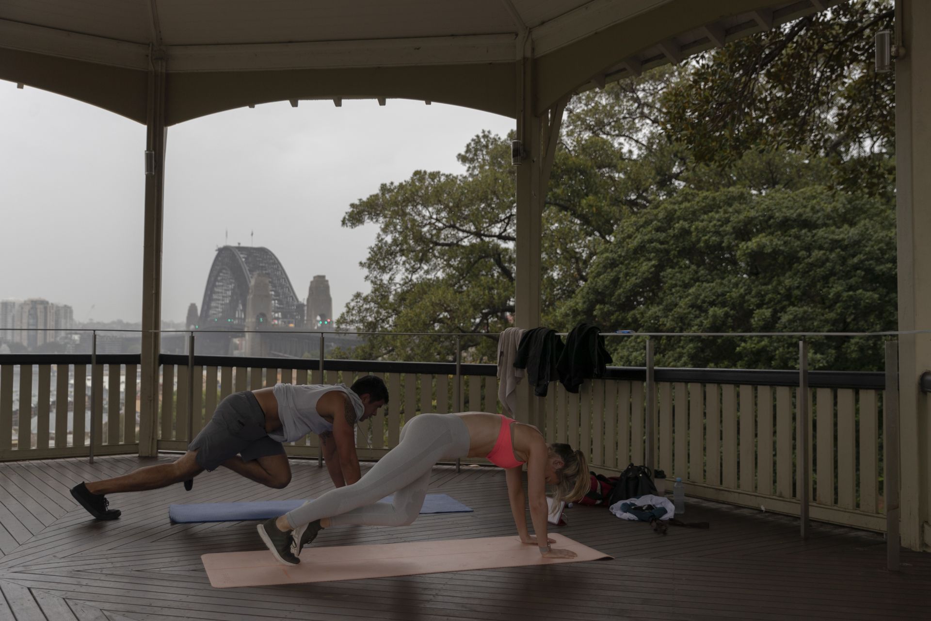 Двойка практикува йога на открито в парк в Сидни