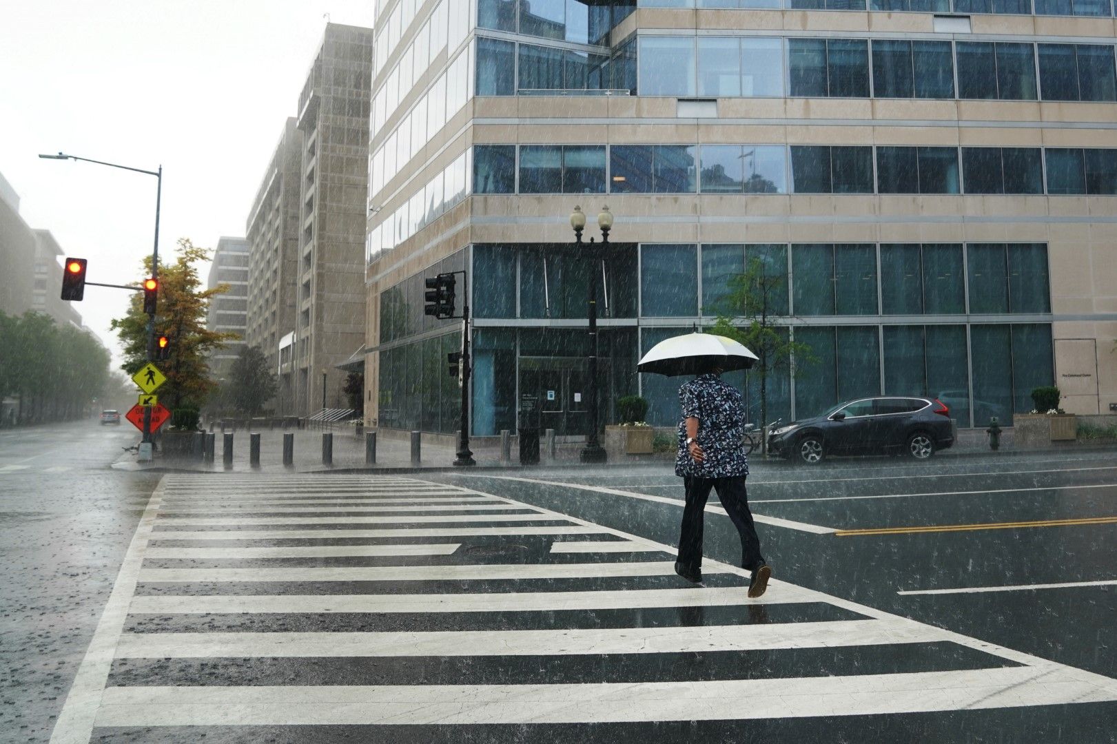 Празни улици, дъждовен ден, самотна жена пресича край централана на МВФ във Вашингтон, 15 април