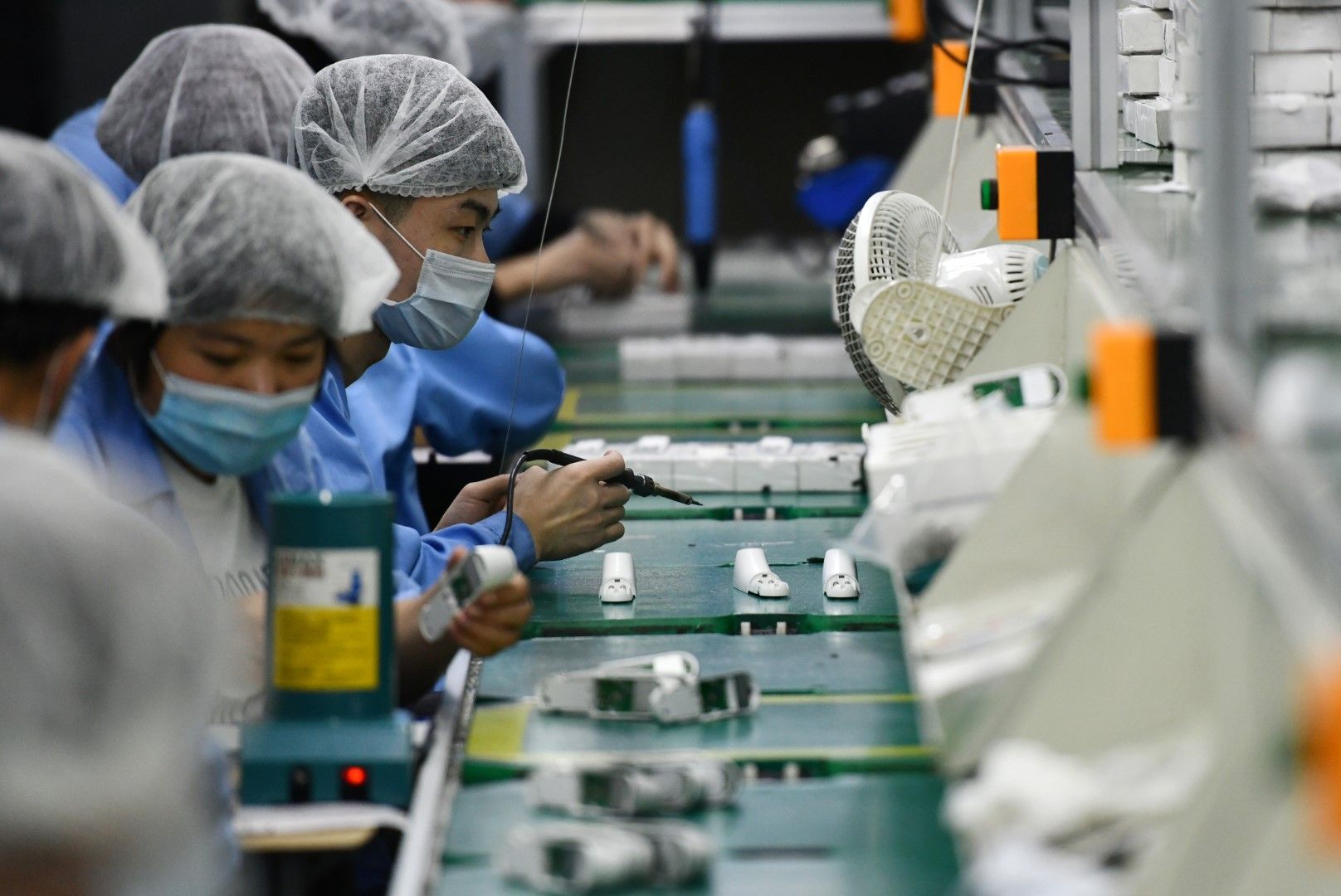 Работници произвеждат инфрачервени термометри в китайски завод. Китай ще продължи да изнася медицинско оборудване и защитни средства, като ще повиши изискванията за по-високо качество на изнасяното