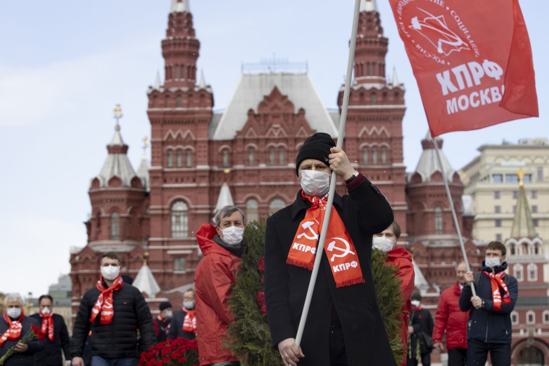 Малка група руски комунисти, носещи защитни маски и червени знамена, поставиха цветя пред мавзолея на Ленин на Червения площад