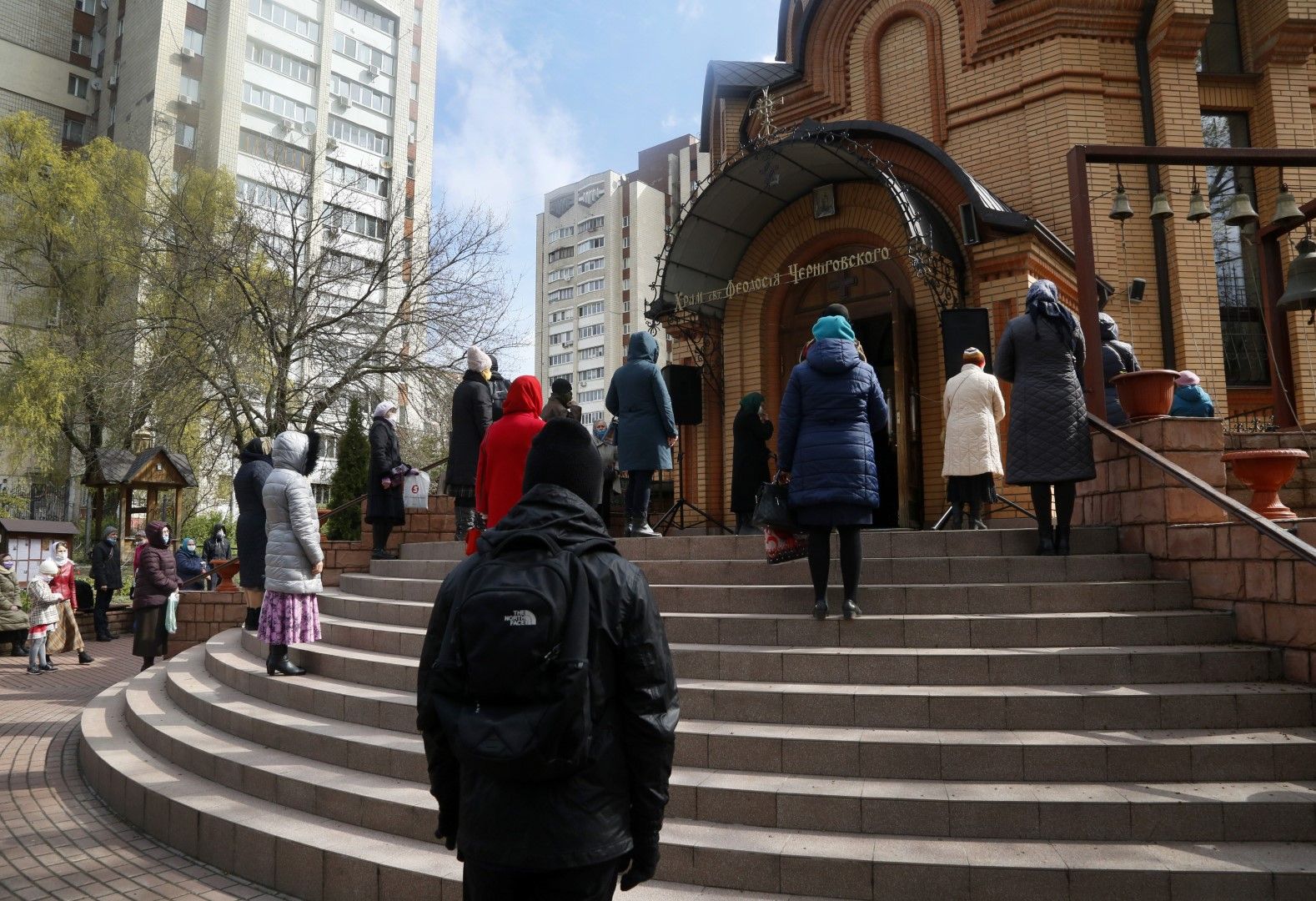 Украинци спазват социална дистанция пред църквата в мемориалния комплекс в Киев за жертвите на Чернобилската катастрофа