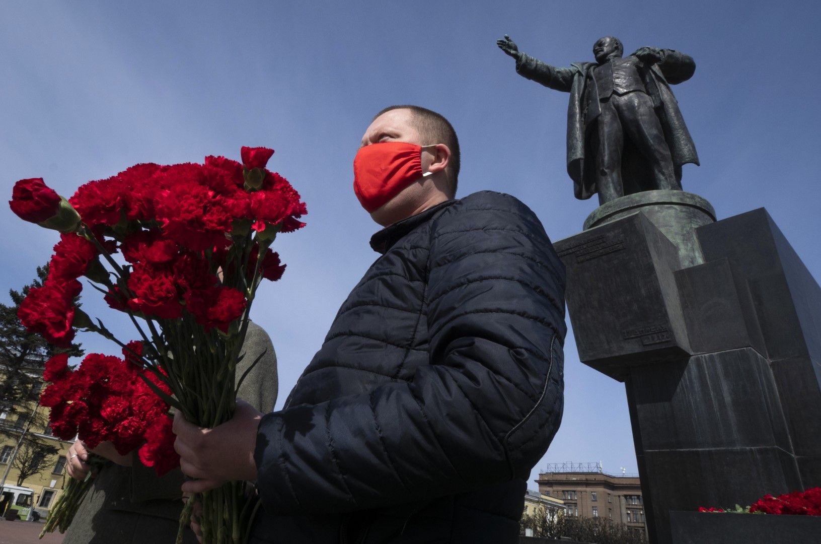 Поддръжник на комунистическата партия е застанал с маска на лице пред паметника на Владимир Ленин в Санкт Петербург по случай 150-годишнината от рождението му, 22 април 