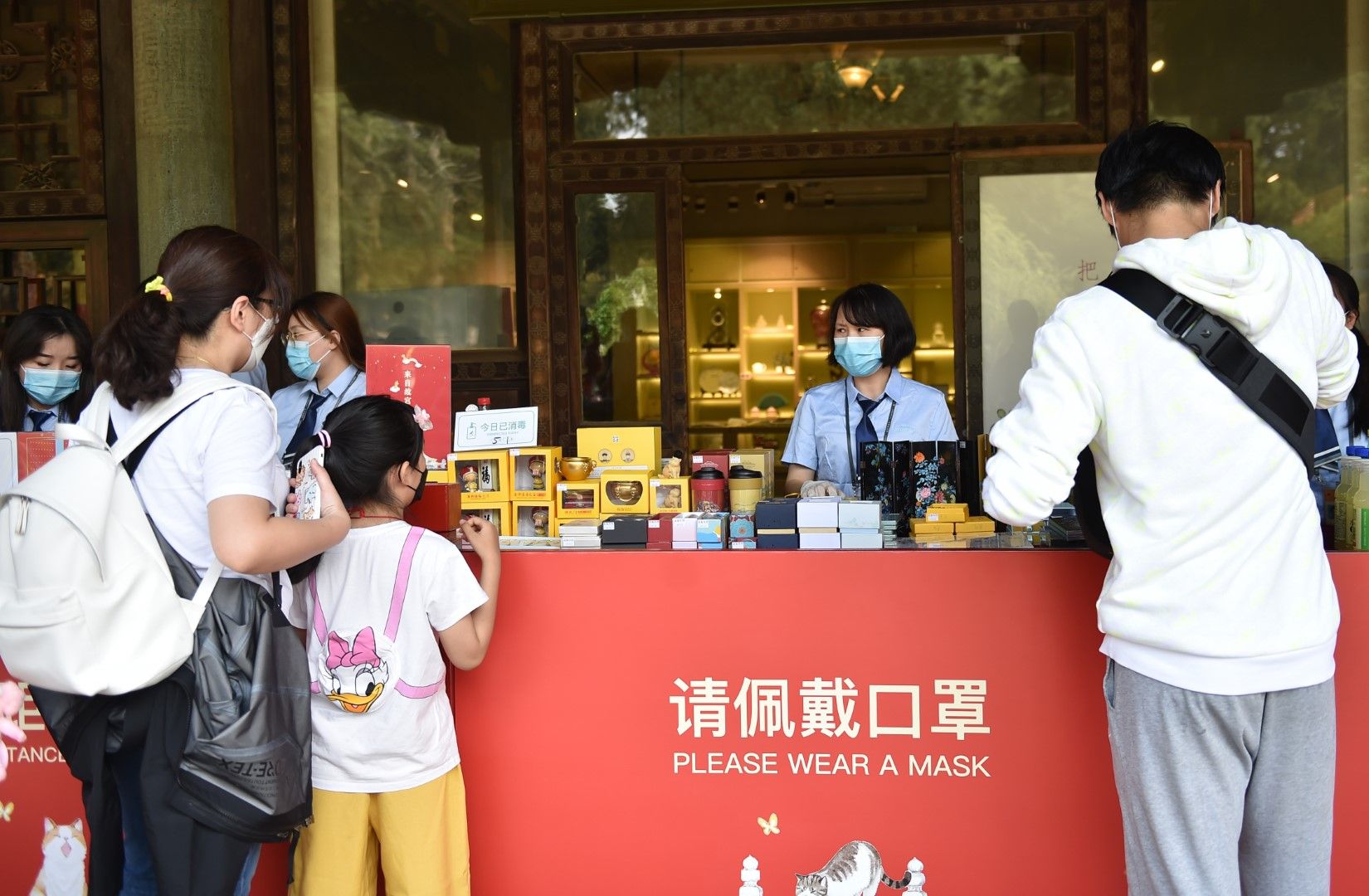 Посетители купуват сувенир в музейния комплекс на Двореца в Пекин при спазване на карантинните мерки
