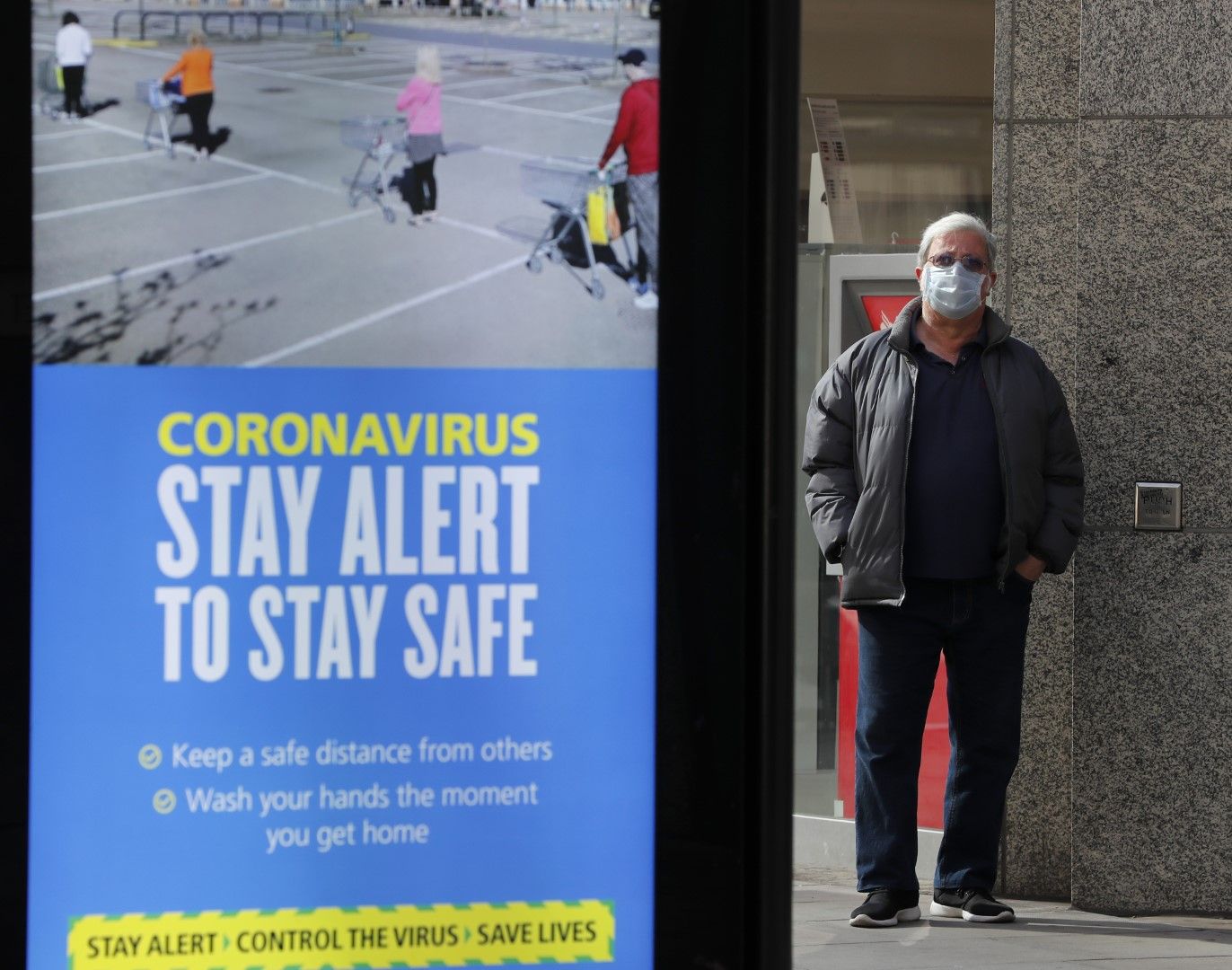 Мъж чака на автобусна спирка в Лондон, до която е поставен плакат с правителствения лозунг: "Бъди нащрек"