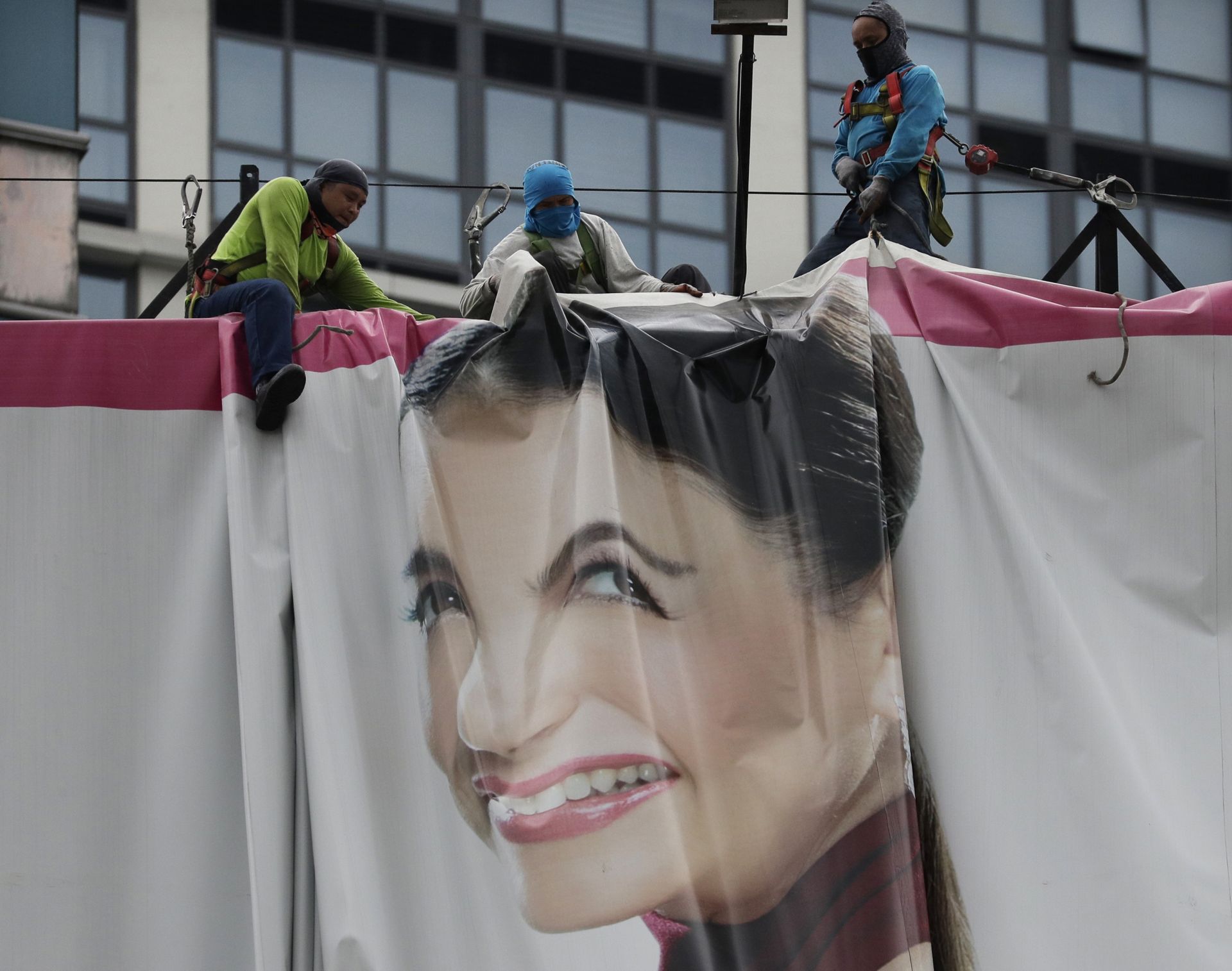 Работници махат огромен билборд, за да го спасят от мощния вятър