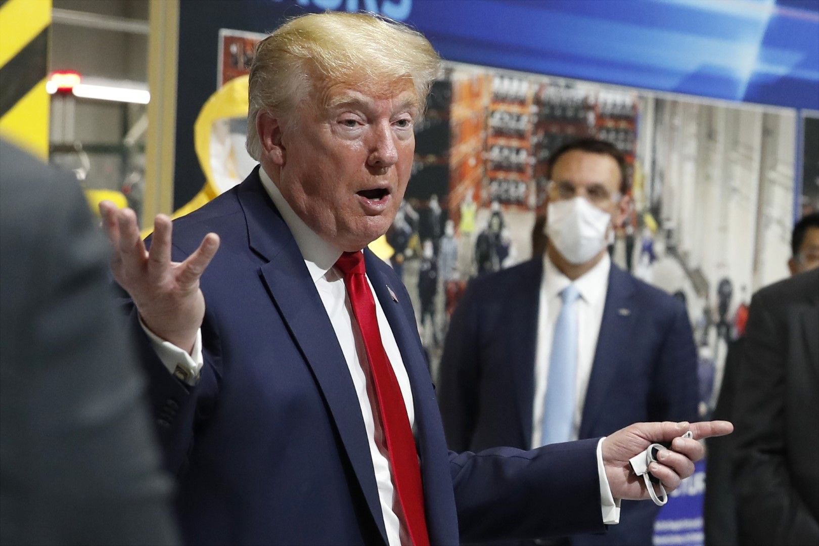 Доналд Тръмп държи маска в лявата си ръка, докато говори пред работници в завод на Форд в Ипсиланти, щата Мичиган, 21 май