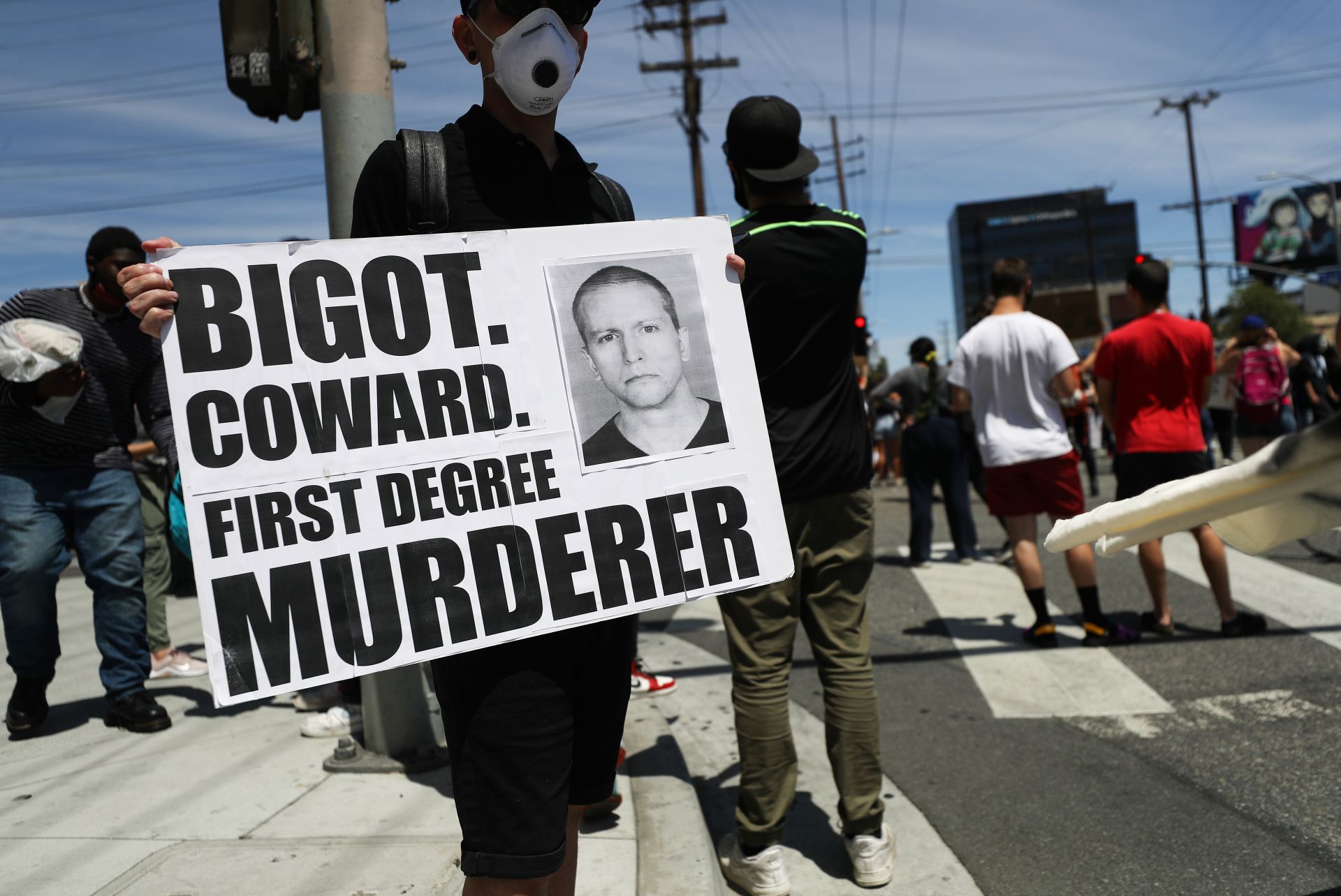 Протестиращи с плакат с лика на Дерек Шовин - полицаят, задържан за убийството на Джордж Флойд