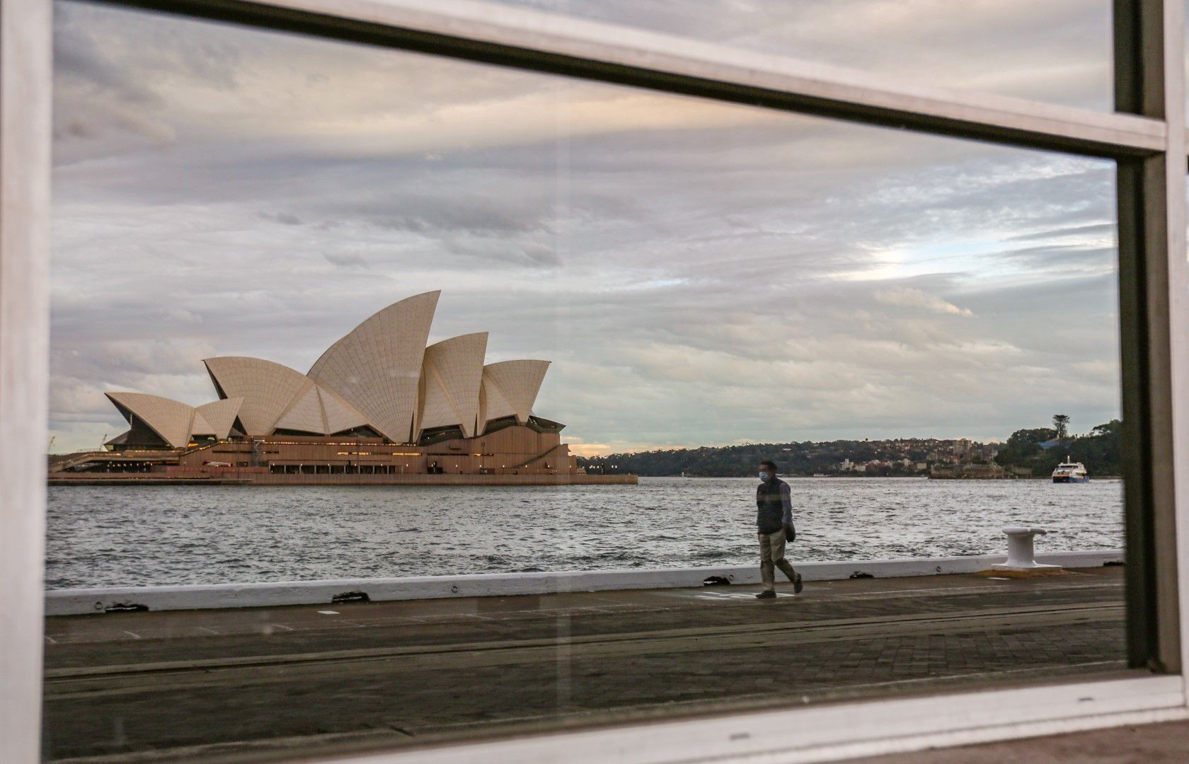 Операта в Сидни се отразява в огледалото на затворен ресторант. Седемте най-големи щата вдигнаха ограниченията от понеделник