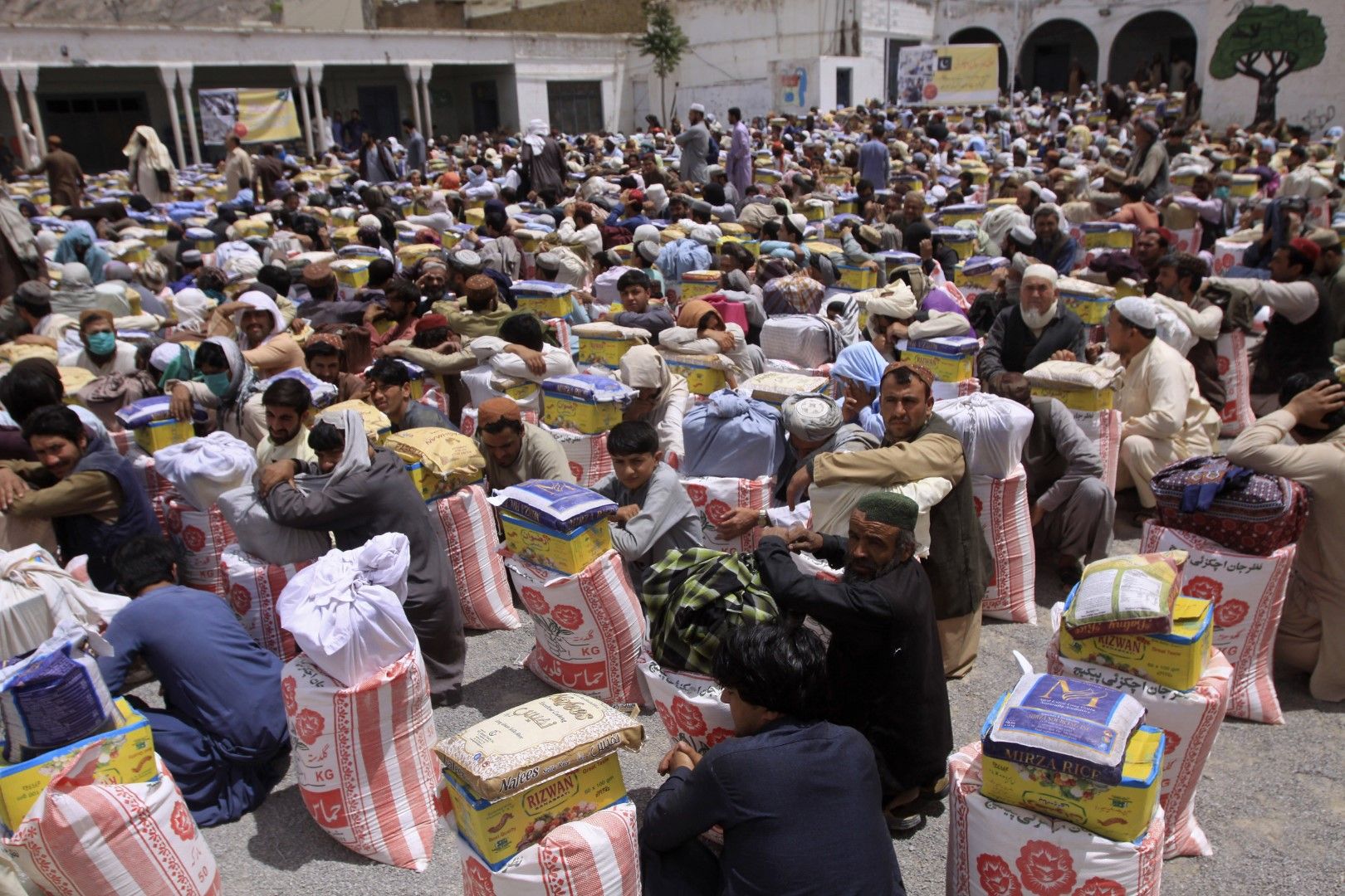 Безработни пакистанци получават помощи под формата на храни по време на ограничителните мерки, 27 април