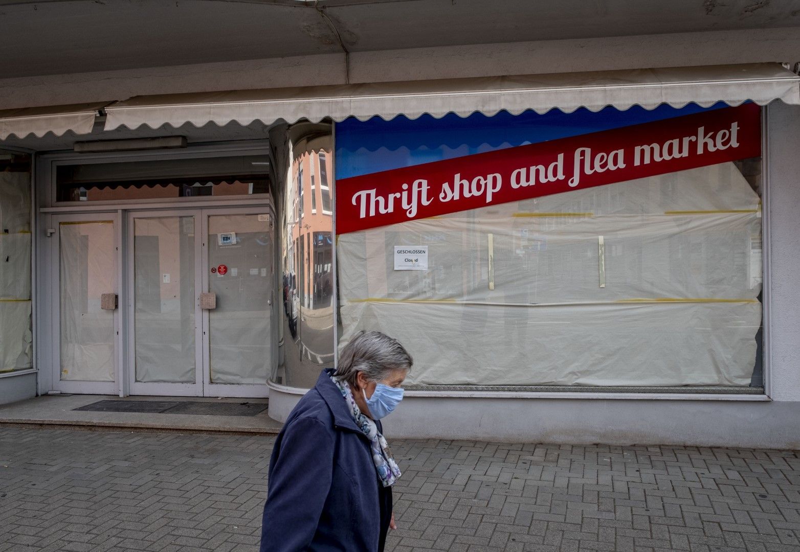 Жена преминава покрай затворен магазин в Ландщул (Рамщайн)