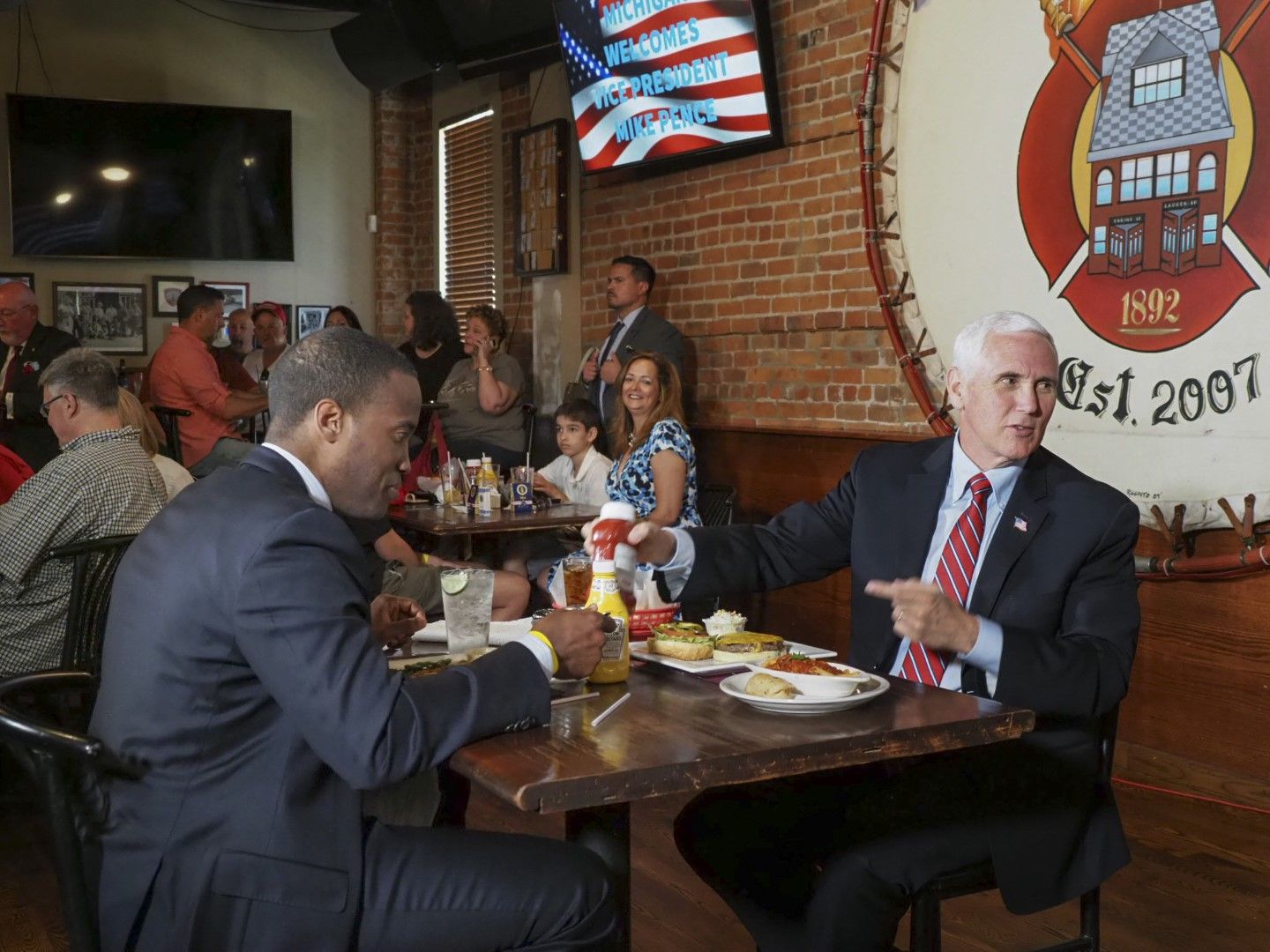 Майк Пенс (вдясно) и кандидатът на републиканците за сенатор Джон Джеймс се хранят в ресторант в Маунт Клемънс, щата Мичиган, 18 юни 