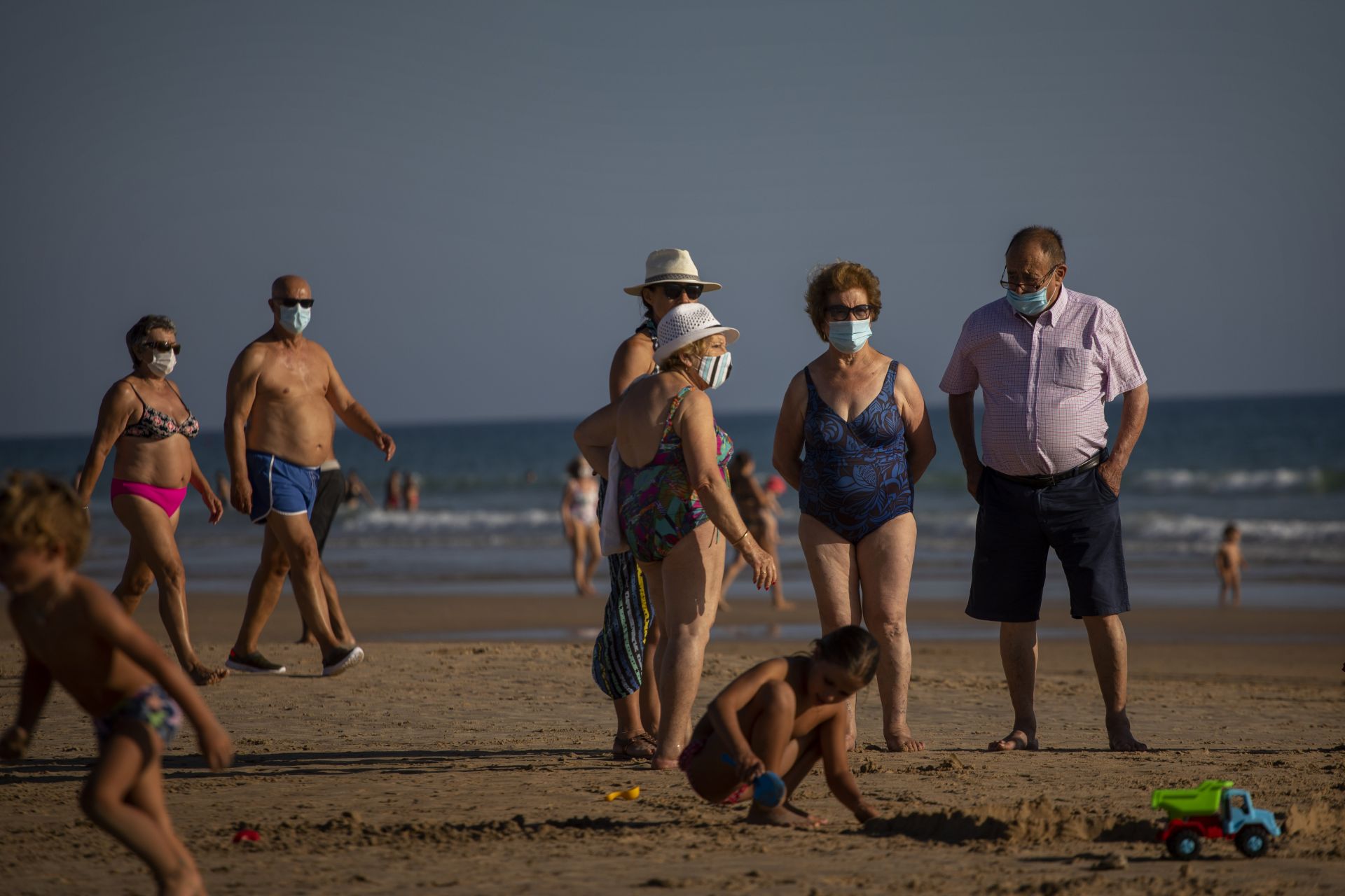 Хората, носещи маски за лице, остават на плажа в Барбате, провинция Кадиз, на юг от Испания