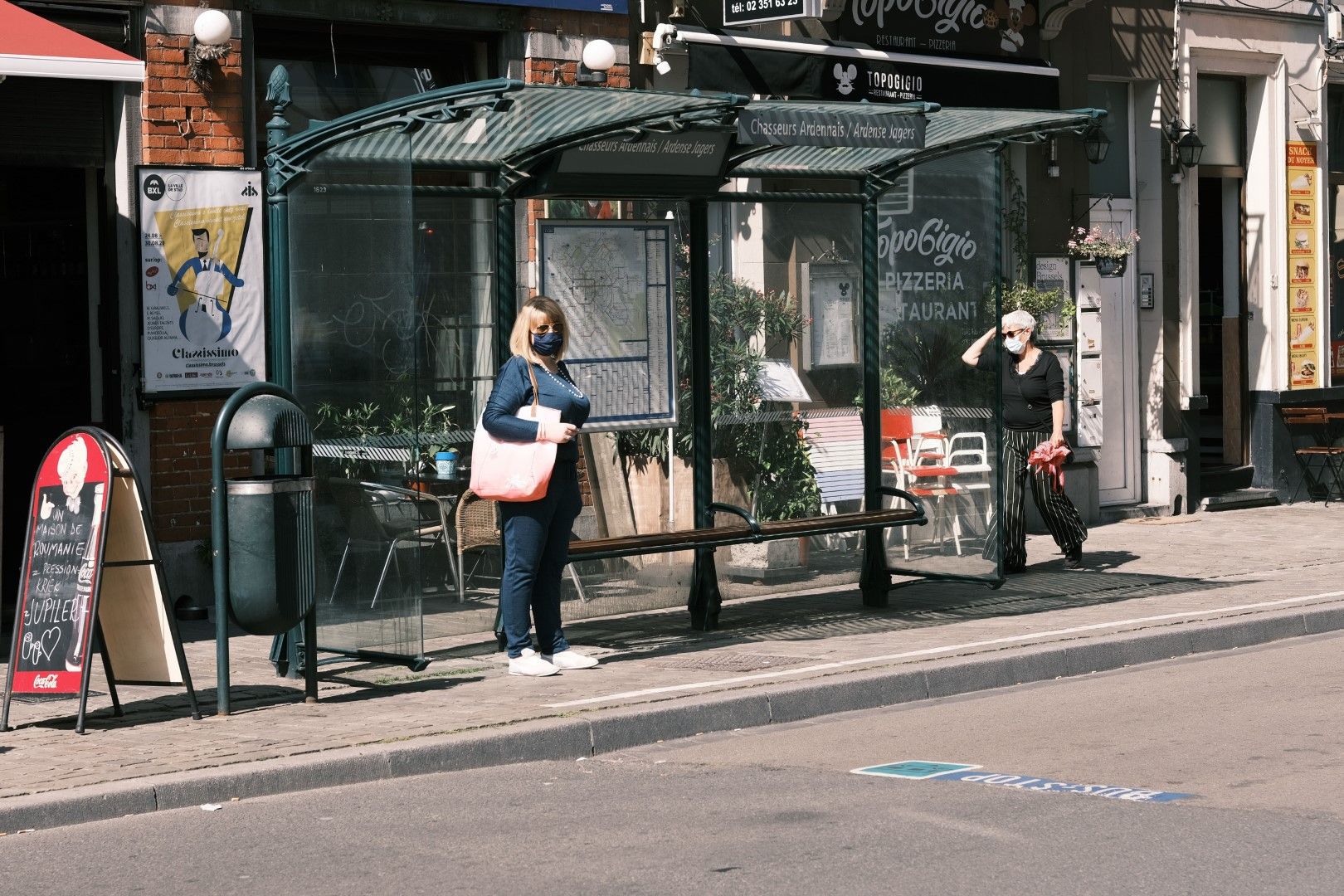 Жена с маска чака автобус на спирка в Брюксел, 29 юли