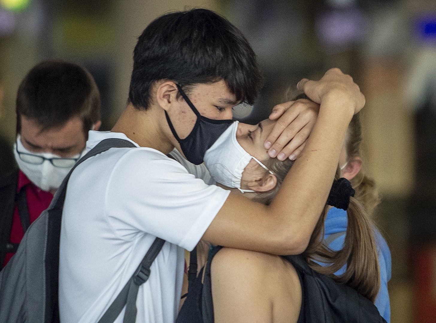 Млада двойка се целува през маските "за довиждане" на летището във Франкфурт, 3 август