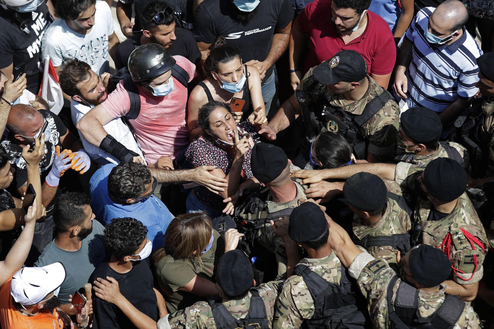 Жена крещи на ливански войници по време на разправии с войниците, които препятстват пътя, докато френският президент Еманюел Макрон посещава квартала Джемайзе
