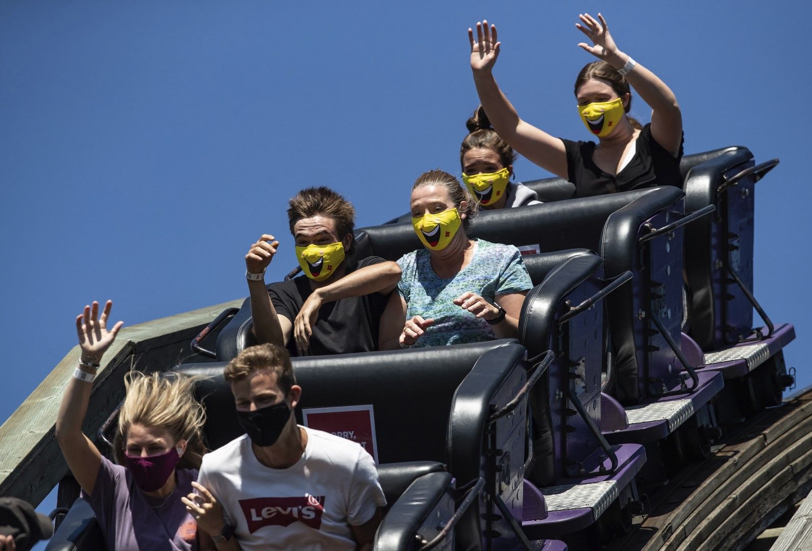 Младежи с маски се веселят на лунапарк във Ванкувър