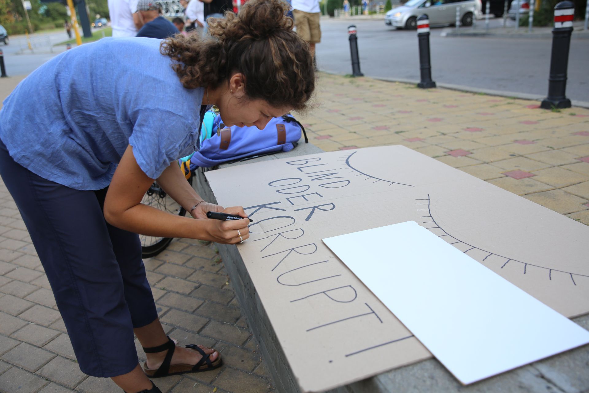 Активистка подготвя транспарант пред посолството на Германия
