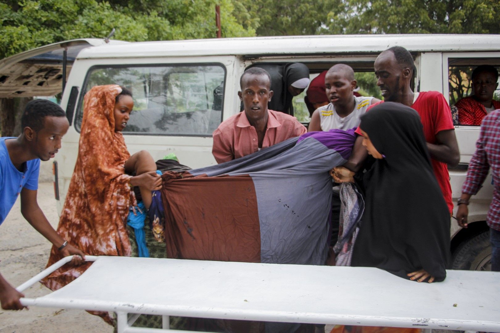 Медици и цивилни помагат при отвеждането на ранена жена след нападението на терористите от Аш Шабаб срещу хотел в Могадишу