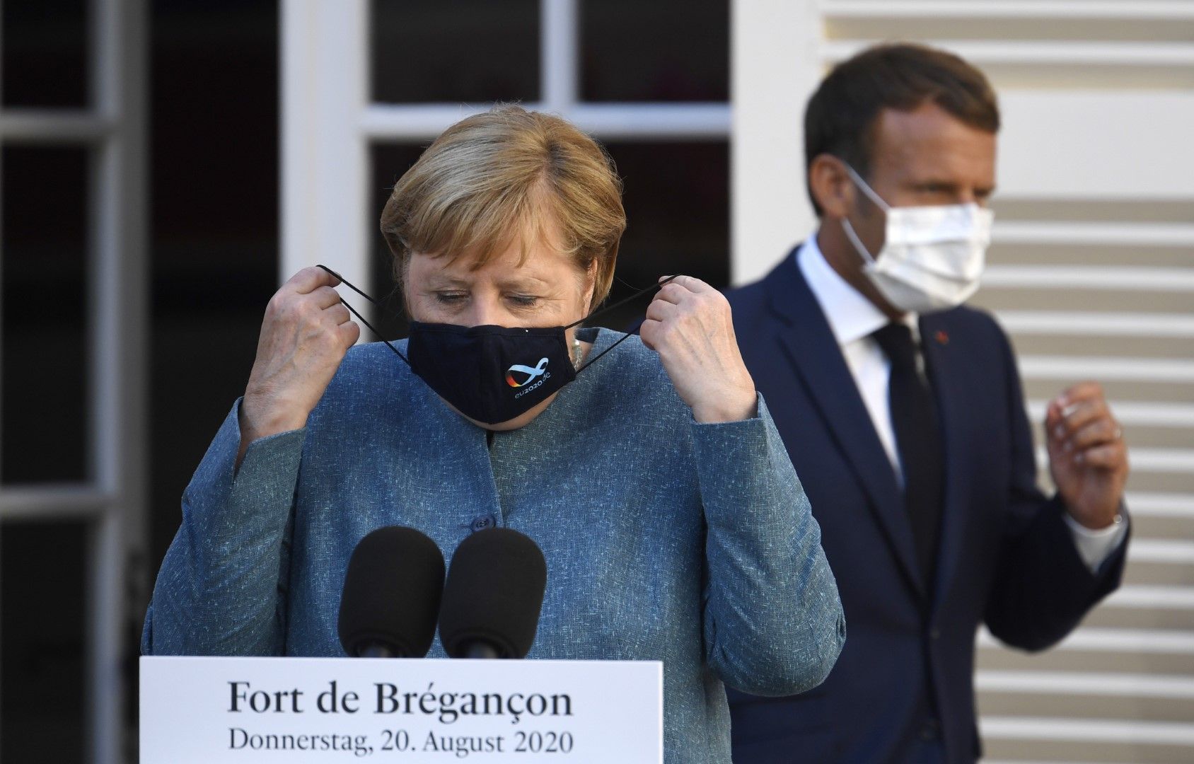 Канцлерът Ангела Меркел и президентът Еманюел Макрон с предпазни маски преди пресконференцията им във Форт Брегансон