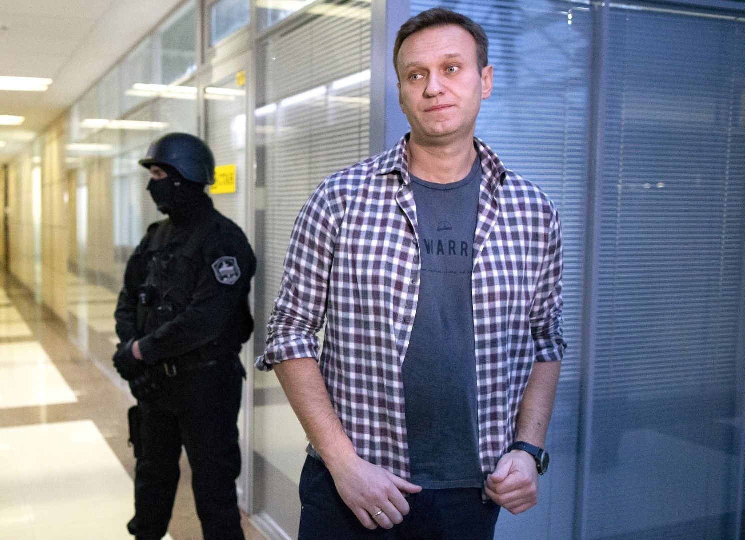 Алексей Навални говори пред медиите в офиса на Фондацията за борба с корупцията, декември 2019 г. До него е служител от службите за сигурност
