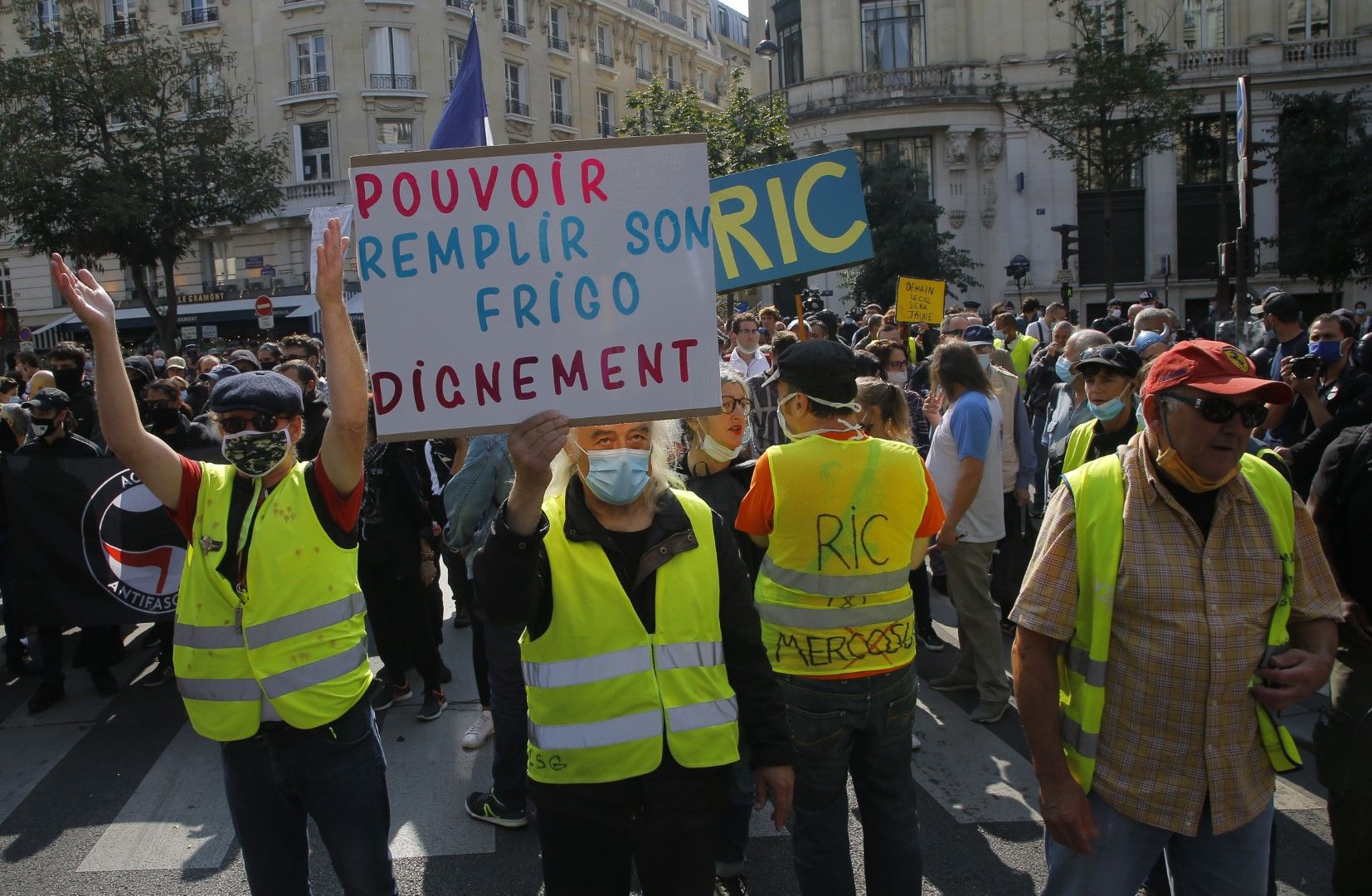 Жълти жилетки на протест в Париж. На плаката пише: Да можеш да напълниш хладилника с достойство