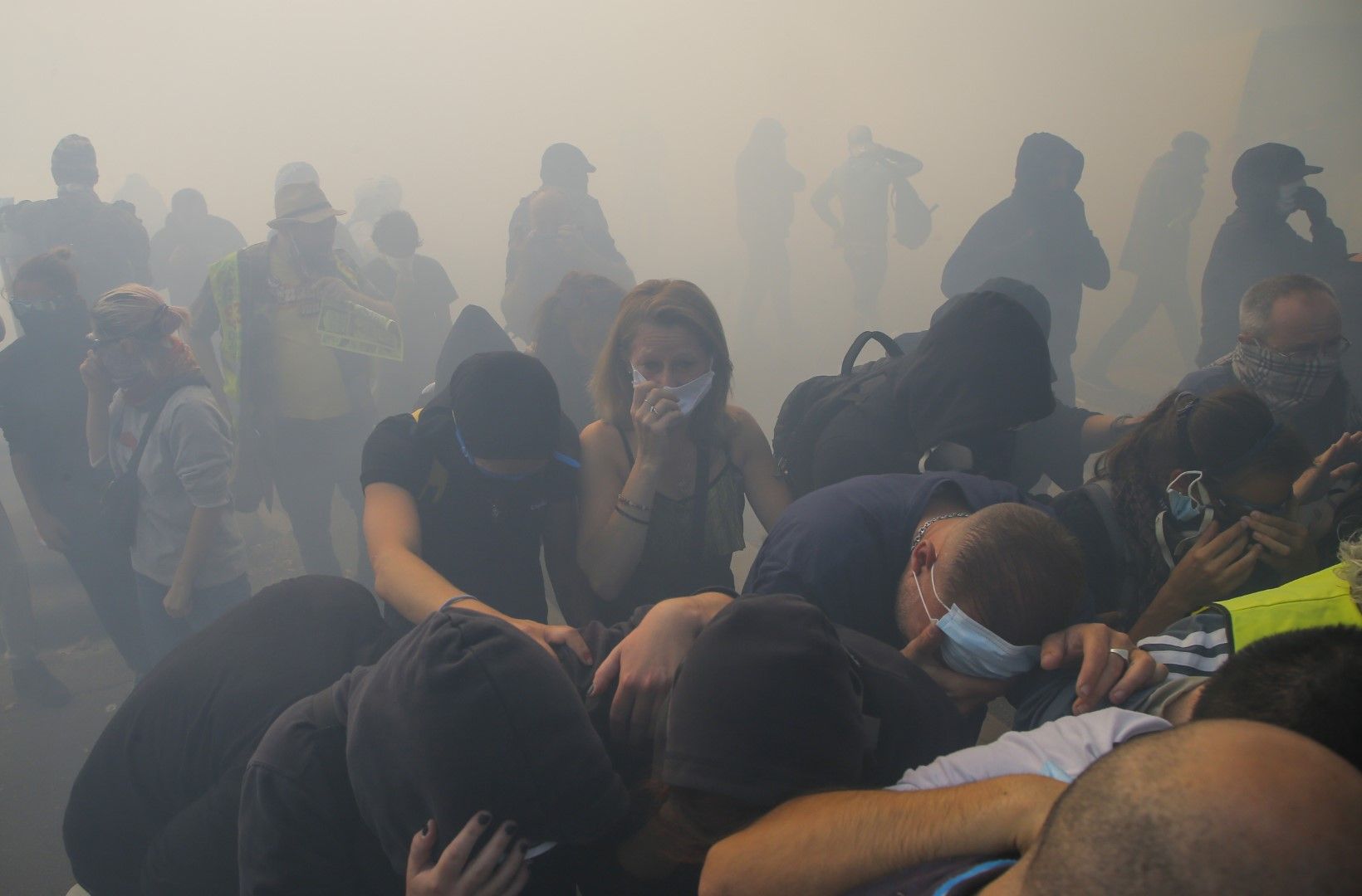 Протестиращи с предпазни маски опитват да избягат от сълзотвония газ