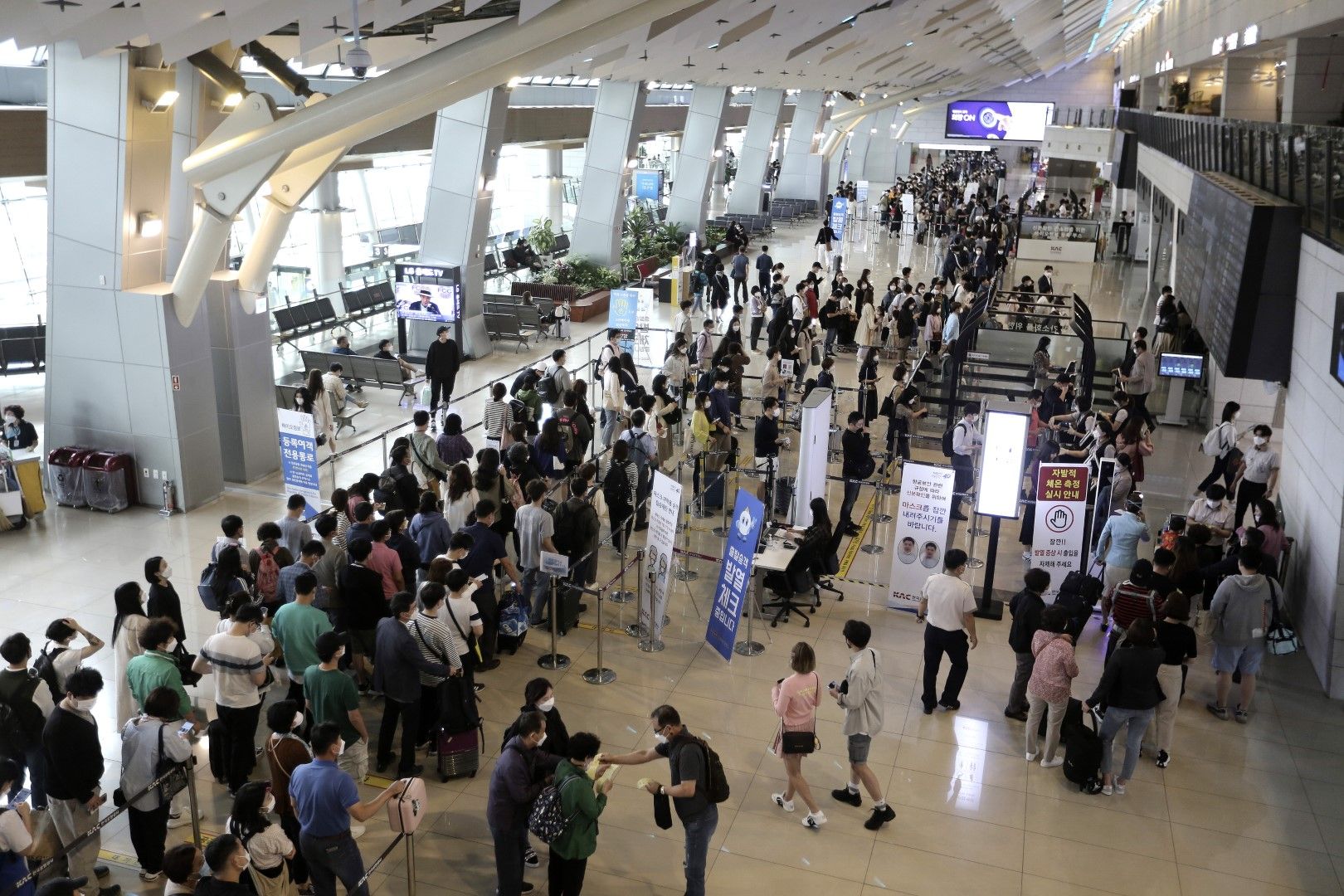 Пътници, носещи предпазни маски, чакат на опашка, за да се качат на самолети преди предстоящия празник Chuseok, корейската версия на Деня на благодарността, на вътрешния терминал на летище "Гимпо" в Сеул, Южна Корея, на 30 септември