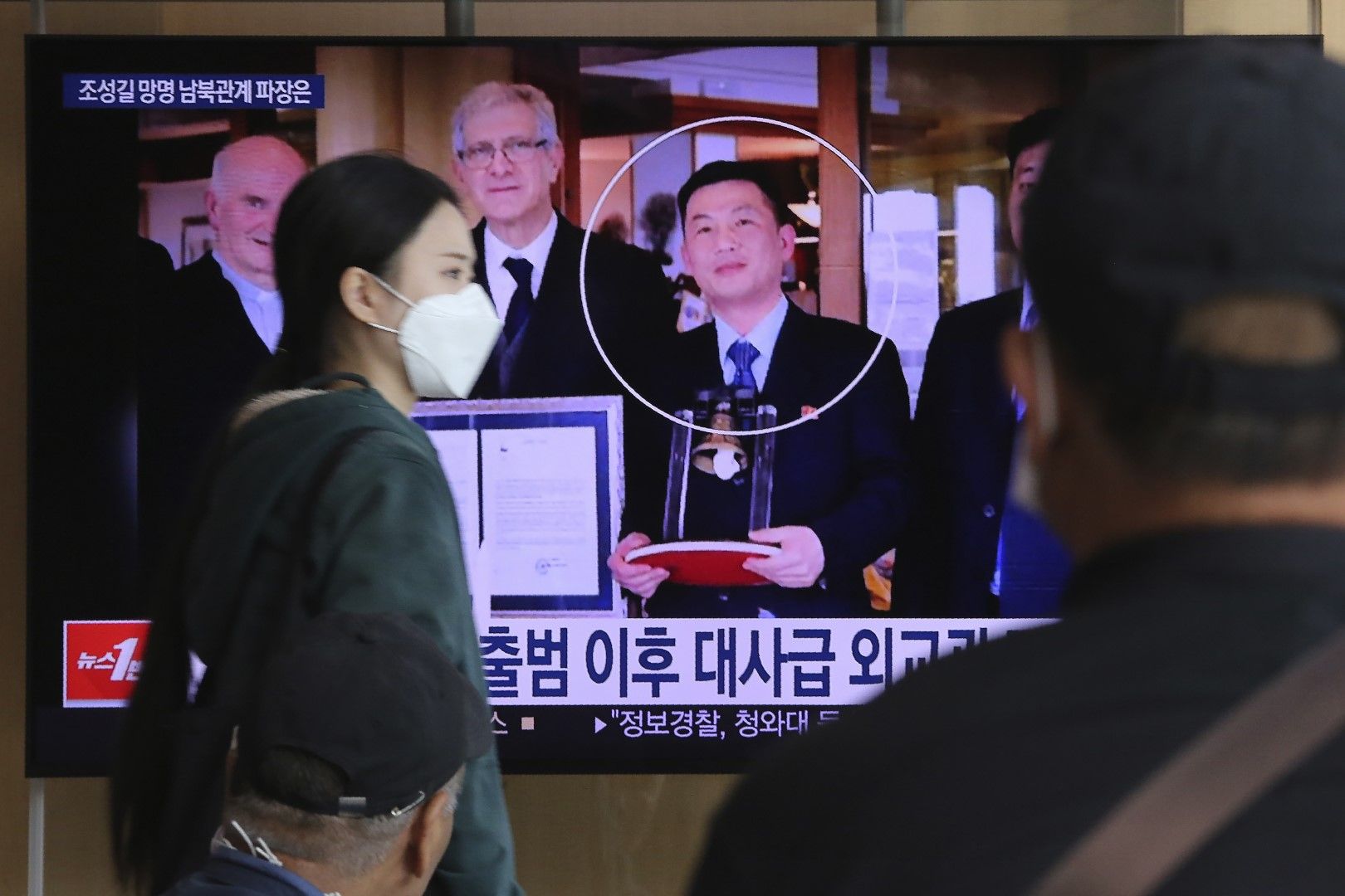 Джо Сон-гил (ограденият в кръг) е на телевизионния екран по време на новинарска програма, излъчвана на жп гара Сеул в Сеул, Южна Корея, сряда, 7 октомври 2020 г. Джо изчезна в Италия в края на 2018 г., а в момента живее в Южна Корея под закрила на правите