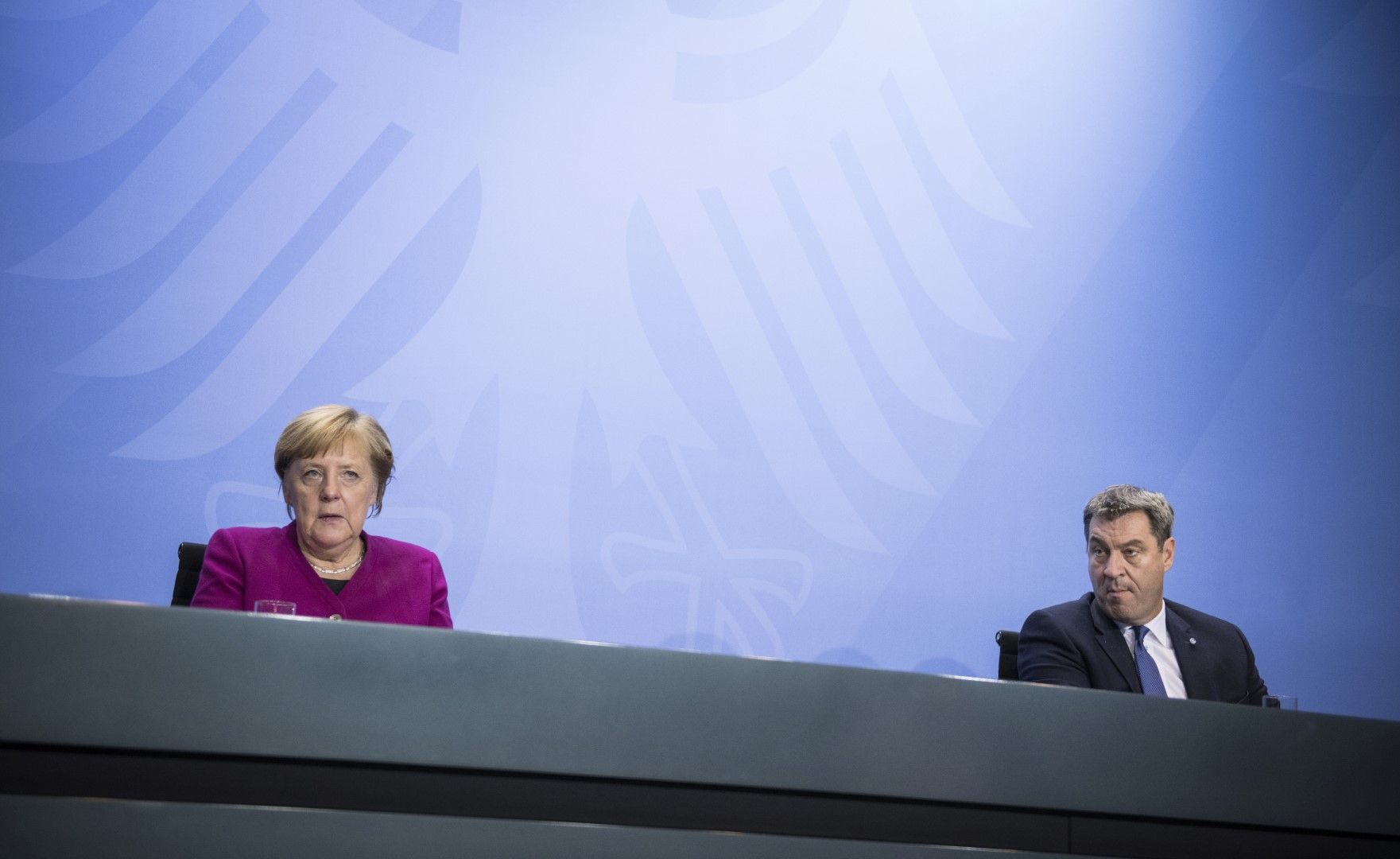 Ангела Меркел и премиерът на провинция Бавария Маркус Зьодер - един до друг, но и на разстояние поне 1.5 метра, по време на заседанието на ръководителите на провинции