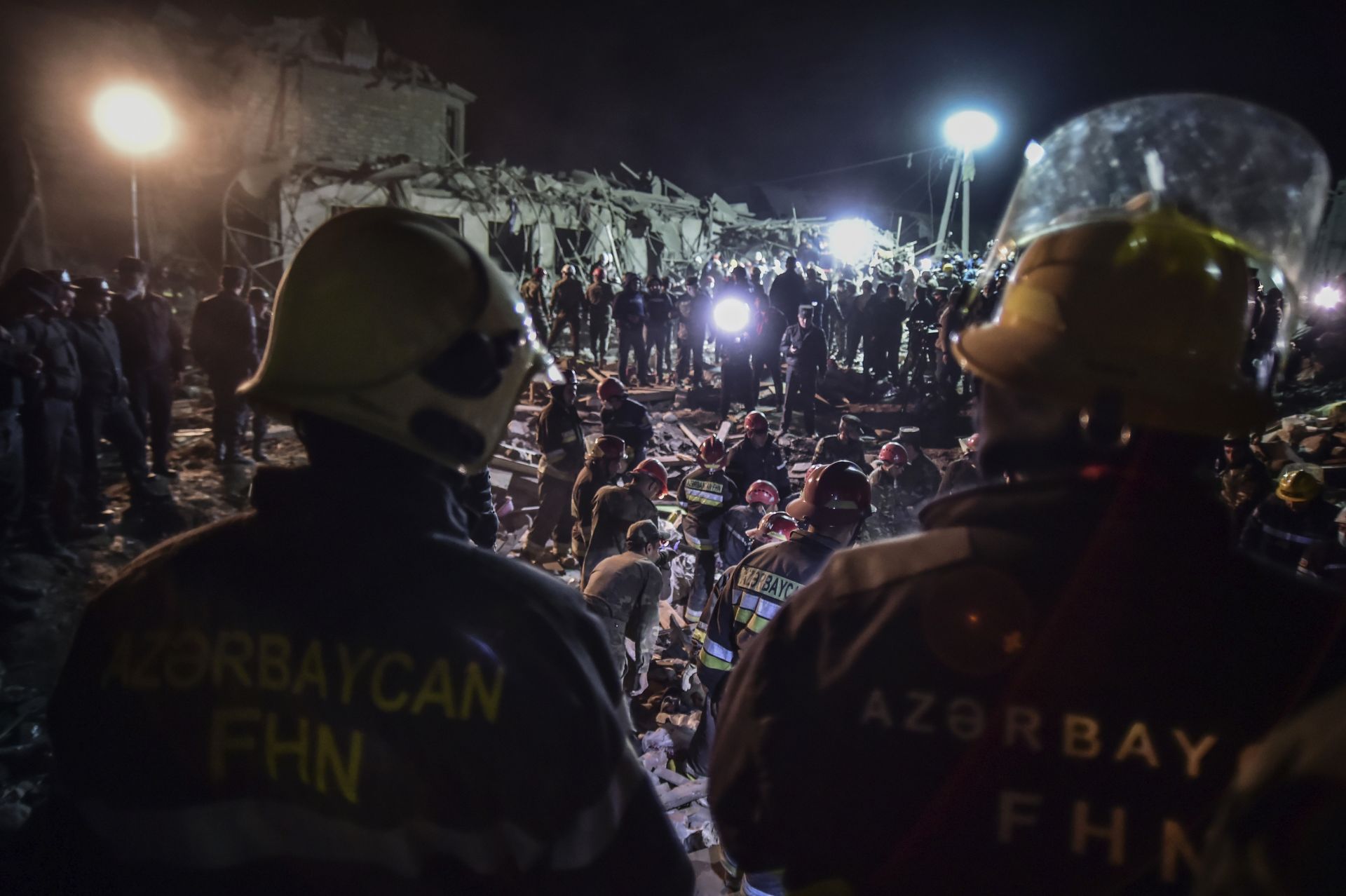 Азербайджански войници и пожарникари се опитват да спасят оцелелите от разрушени къщи в жилищен квартал в Ганджа
