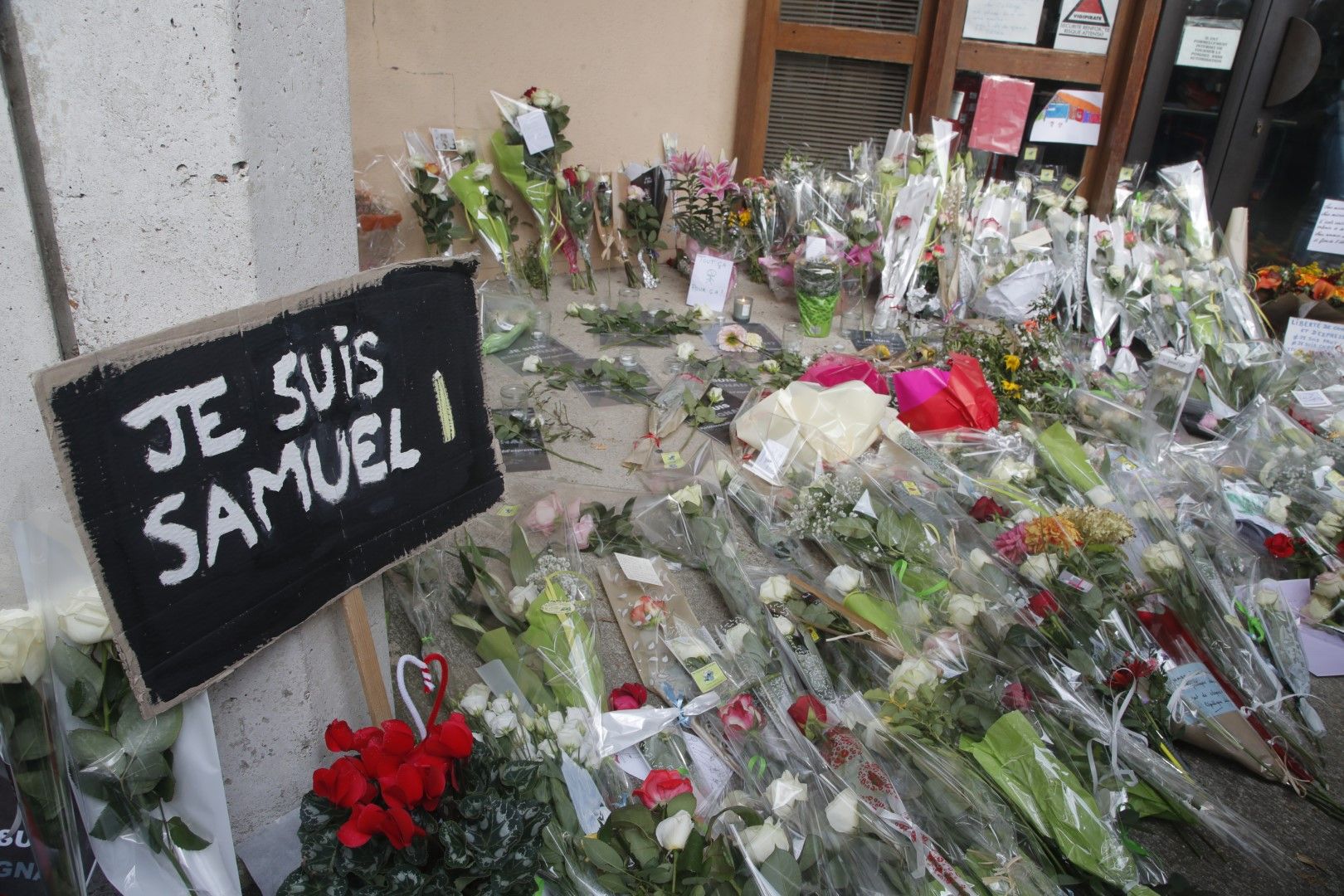 Надпис "Аз съм Самуел" и цветя са поставени на входа на училището, в което учителят Самуел Пати беше обезглавен от чеченец в град, северозападно от Париж