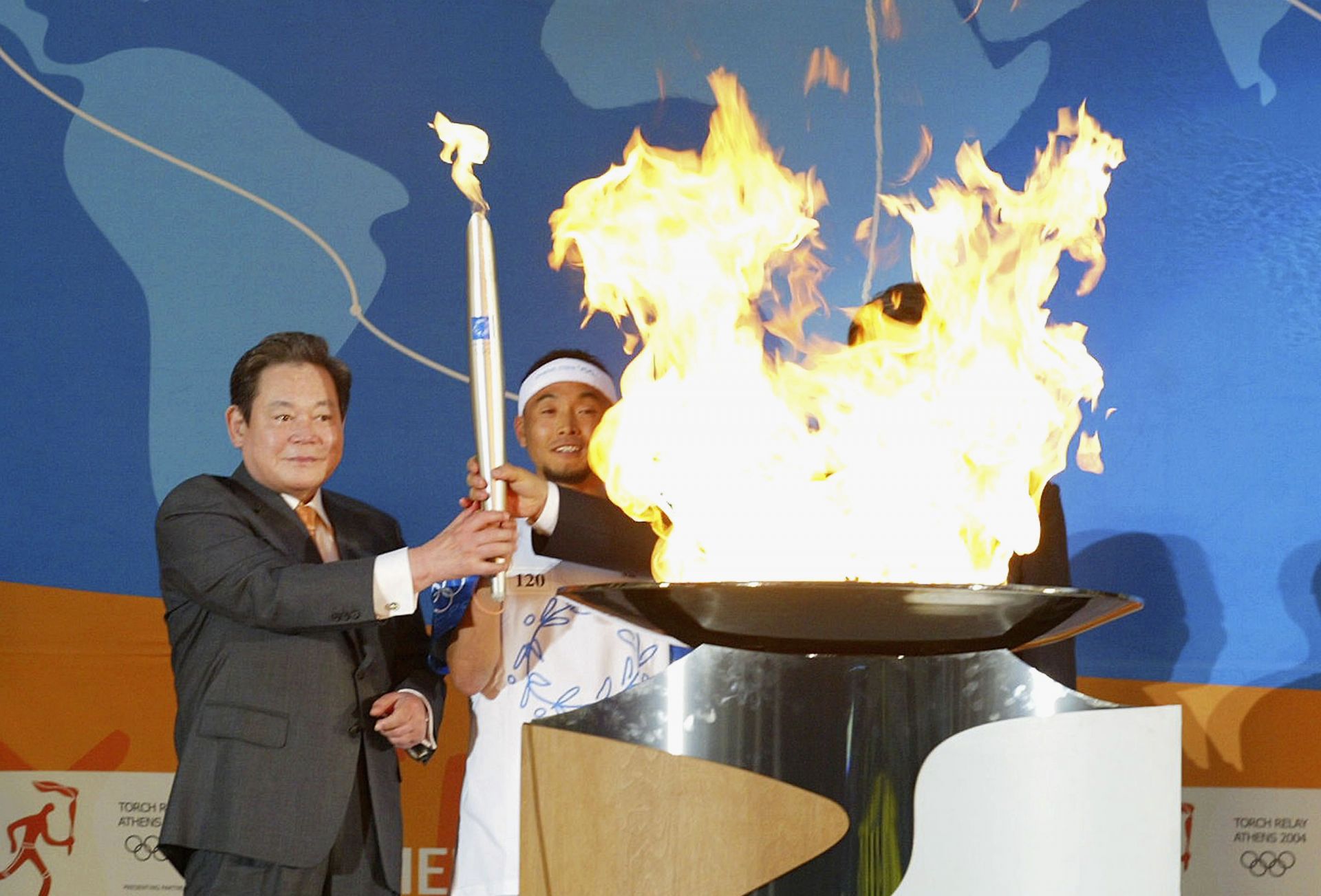 Кун-хи с олимпийския огън в ръце преди Игрите в Атина през 2004 г.