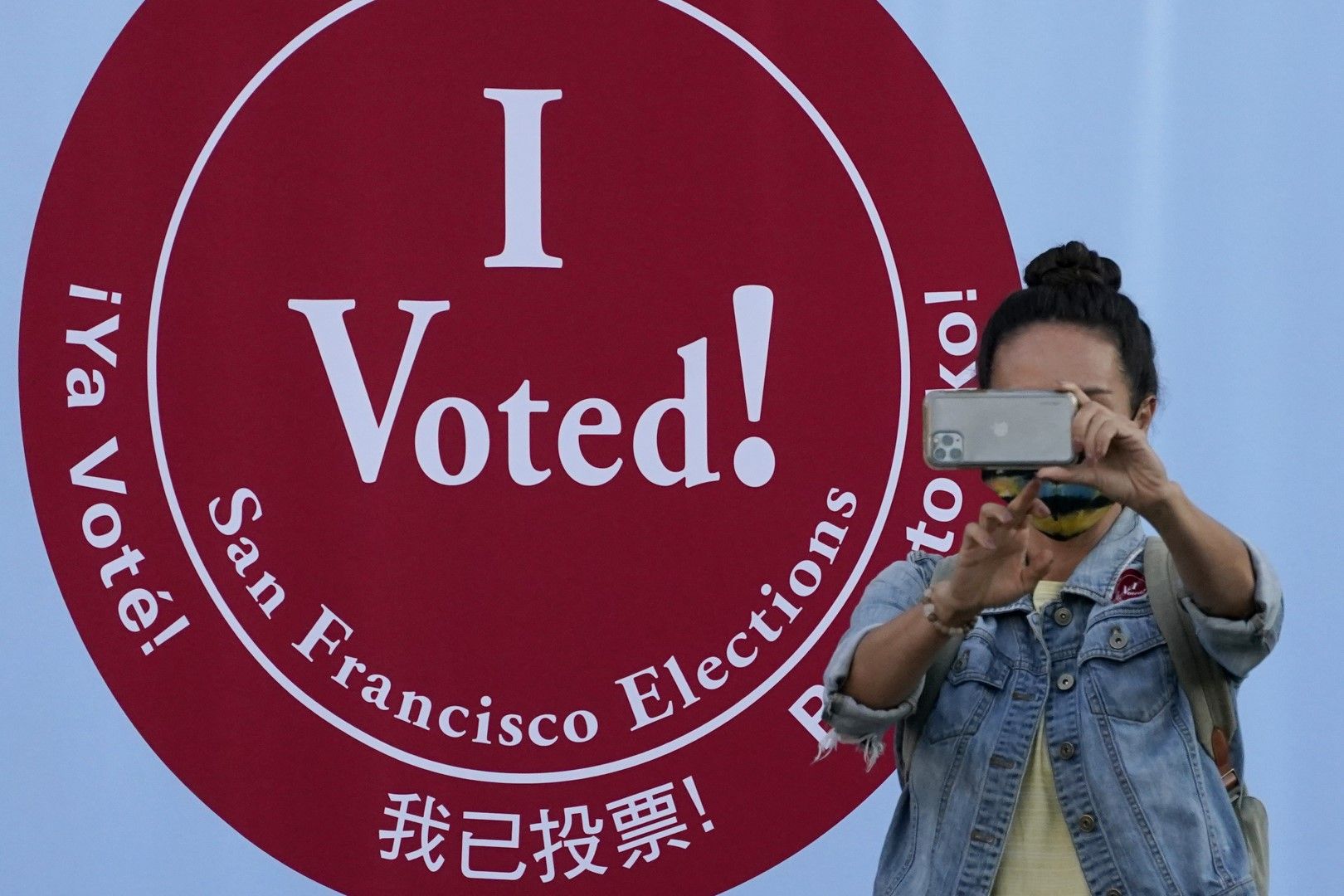 Жена си прави селфи пред избирателна секция в Сан Франциско, на фона на надписа "Аз гласувах!"