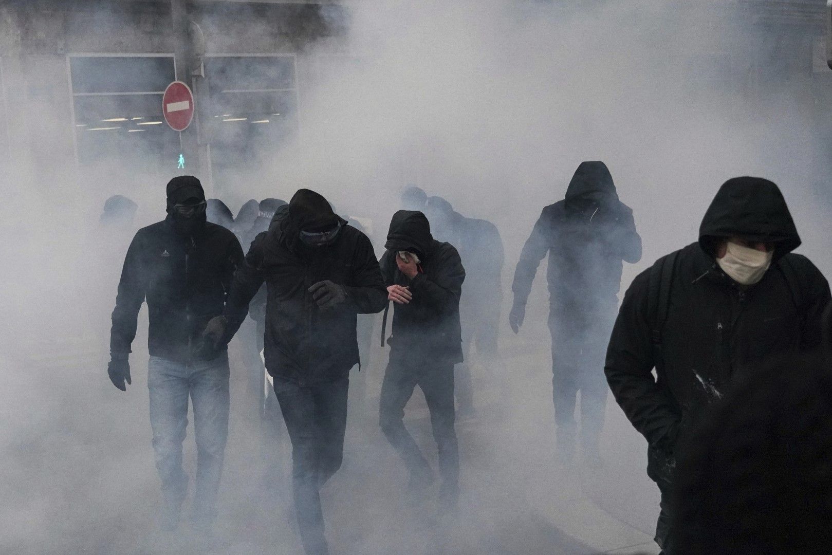 Протестиращи вървят обгърнати от дима на сълзотворен газ при протест в Лион срещу закона за глобалната сигурност