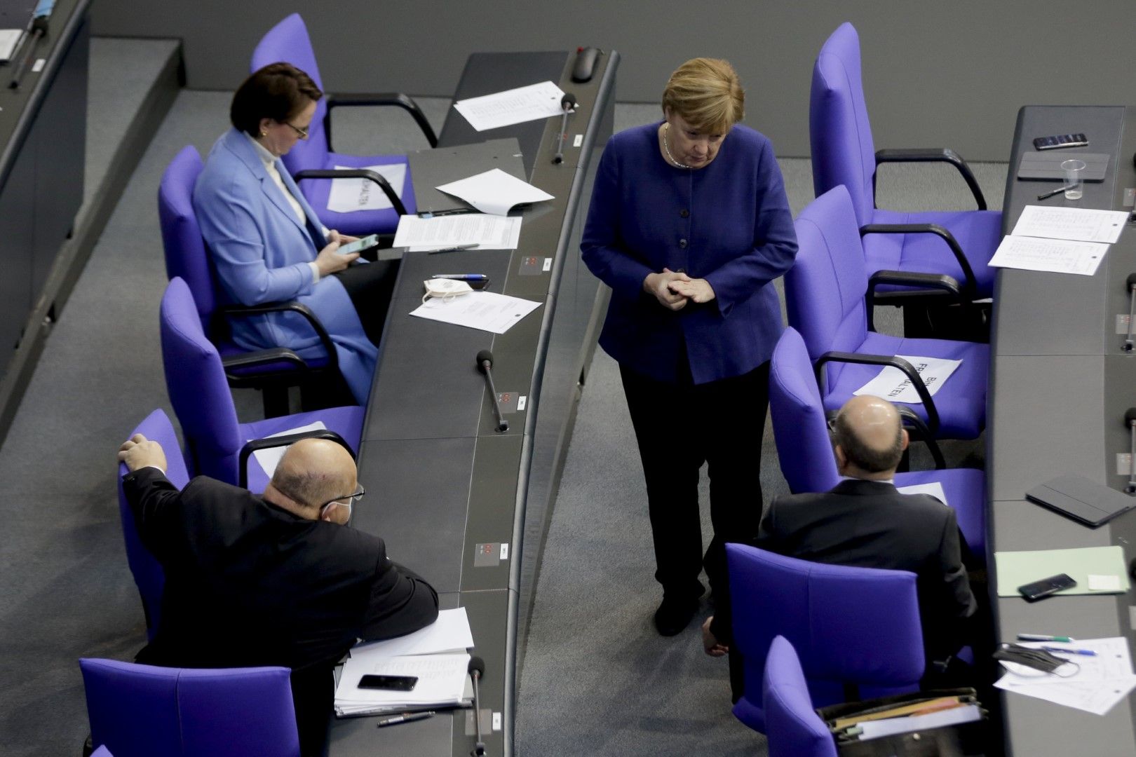 Канцлерът Ангела Меркел разговаря с министрите на икономиката и на финансите Петер Алтмайер (вляво) и Олаф Шолц по време на заседание на Бундестага. Очаква се правителството на Меркел да удължи локдауна зарди пандемията