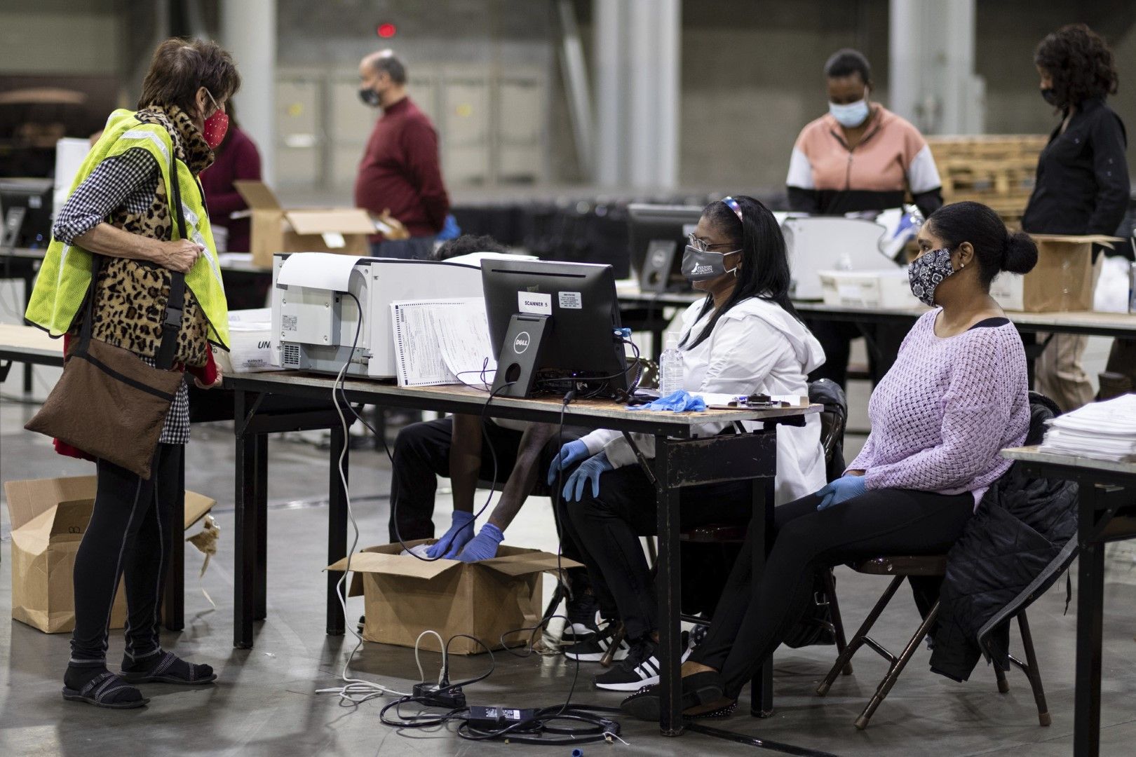 Служители в изборни секции сканират бюлетини в Световния конгресен център в Атланта преди преброяването в щата Джорджия