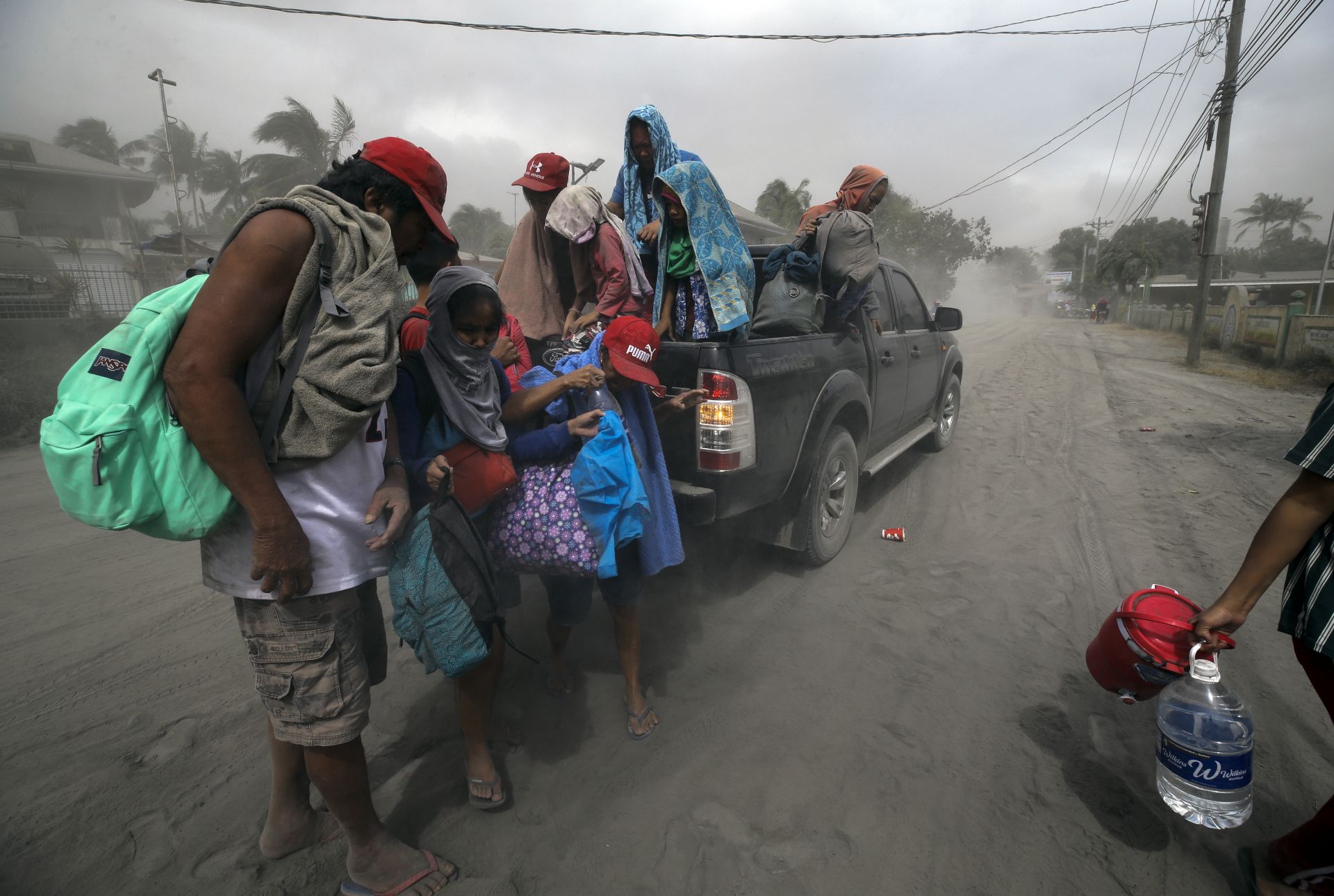 Семейство се евакуира, докато вулканът Таал изхвърля пепел в Лемери, Филипините (13 януари 2020 г.)
