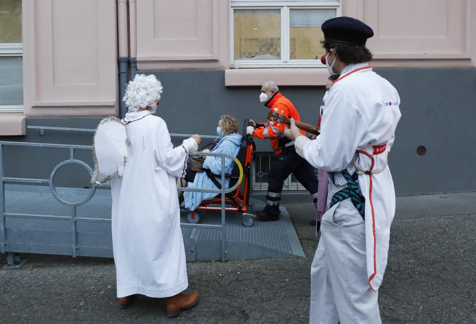 Артисти, облечени като клоуни, забавляват възрастни хора в социален дом в Прага