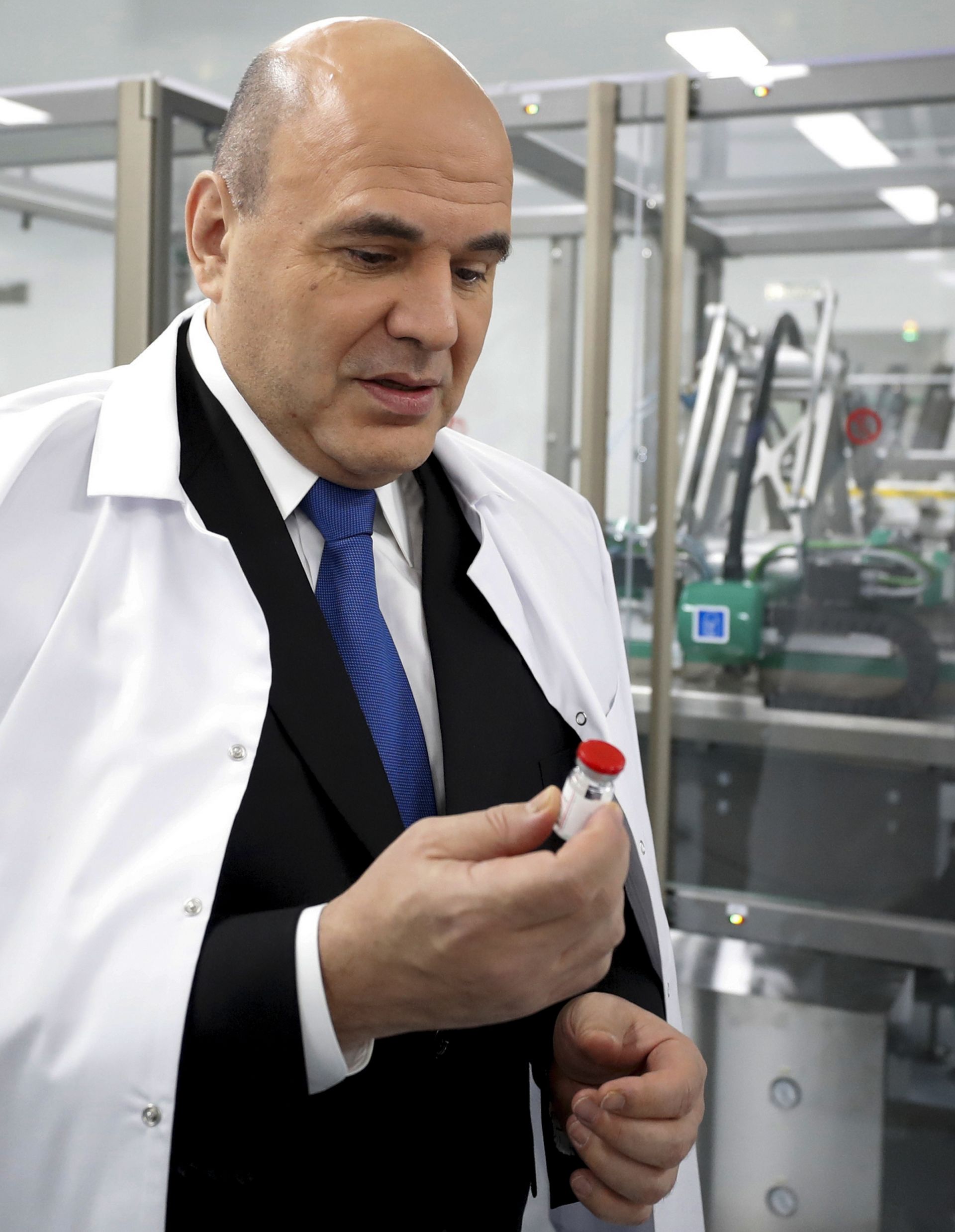 Руският премиер Михаил Мишустин държи доза от проектираната от Русия ваксина Sputnik V при посещение в производствения завод в Стрелна, близо до Санкт Петербург