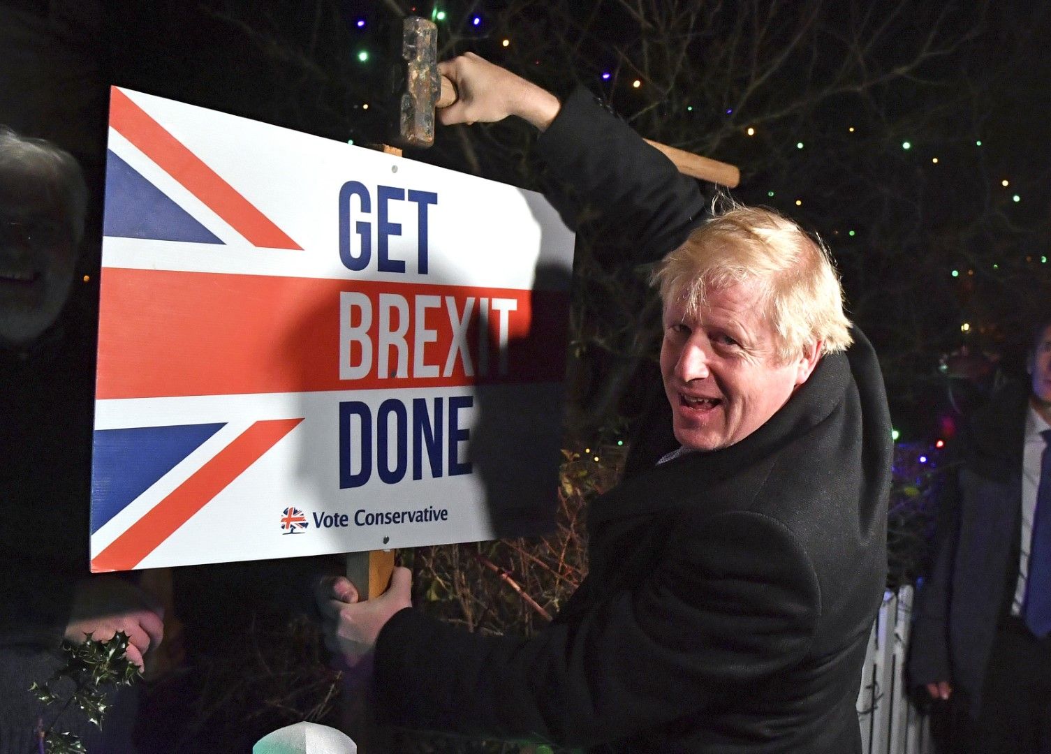 10 дни преди споразумението с ЕС: премиерът на Великобритания Борис Джонсън позира, докато поставя с чук и пирони плакат, на който пише „Да приключим Брекзит"  