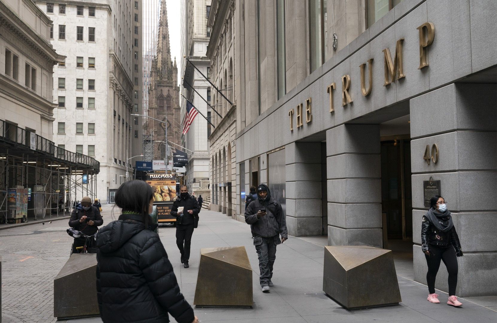 Хора минават покрай сградата на Тръмп във финансовия квартал на Ню Йорк (Wall Street office tower), сряда, 13 януари 2021 г. 