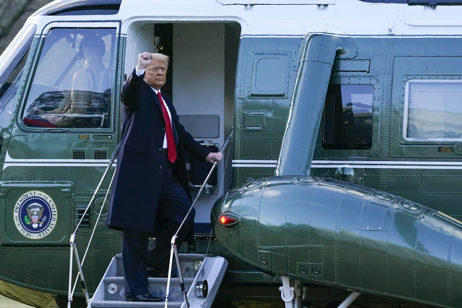 Доналд Тръмп прави жест, качвайки се на президентския хеликоптер, който ще го отведе до военна база "Андрюс" 
