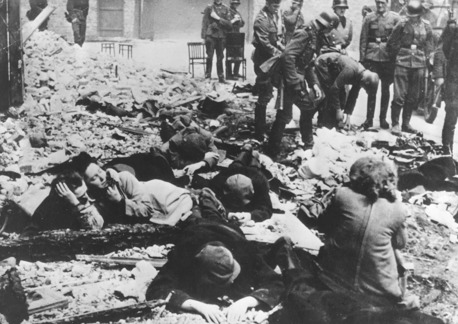 Войници от СС претърсват вещите на еври по време на разрушаването на Варшавското гето в Полша през 1943 г.